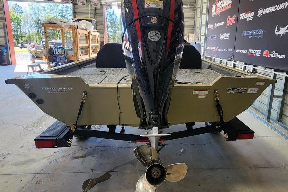 2026 Tracker Pro Team 195 boat in a showroom, showcasing its powerful outboard motor.