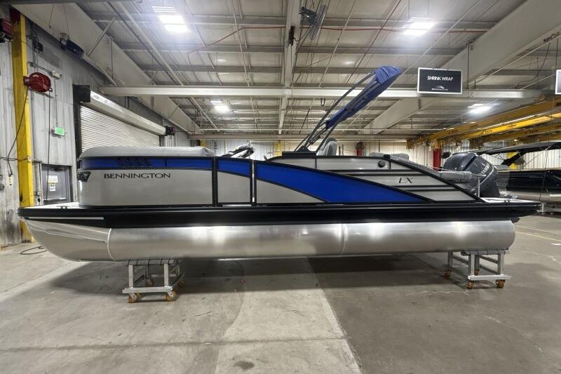 2026 Bennington 23 LXS Swingback pontoon boat in a warehouse setting.