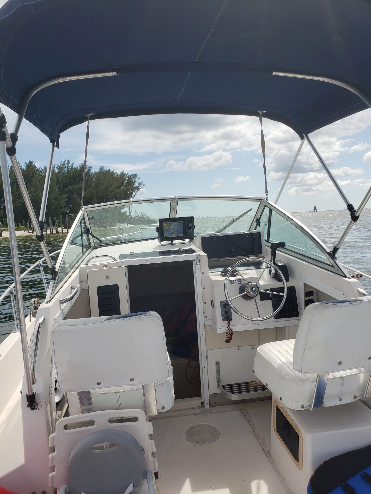 The image shows the cockpit of a 1995 Grady-White Explorer 24 boat with blue seats and a helm.