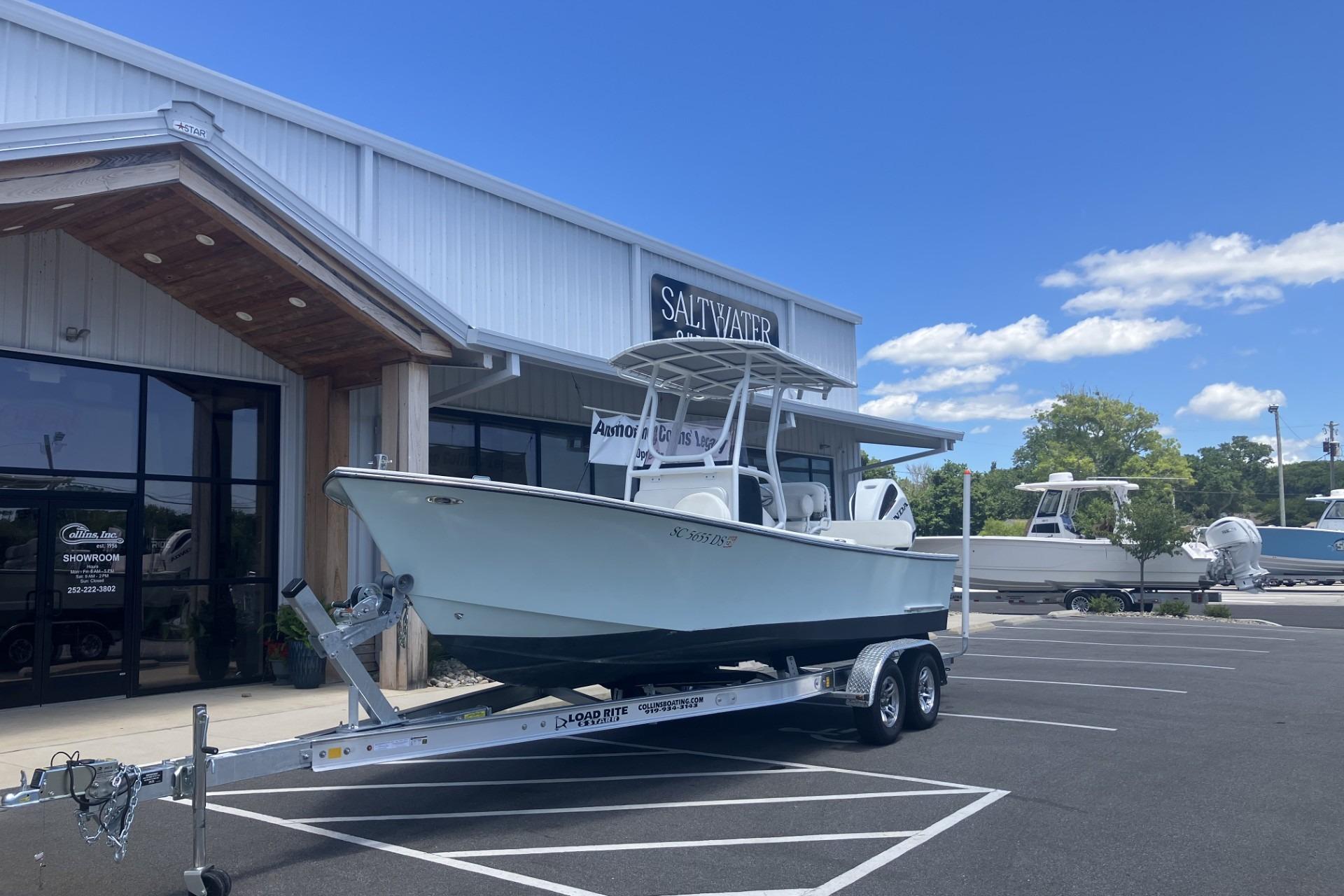 2022 May-Craft 2300 CCX boat on trailer outside showroom under blue sky.