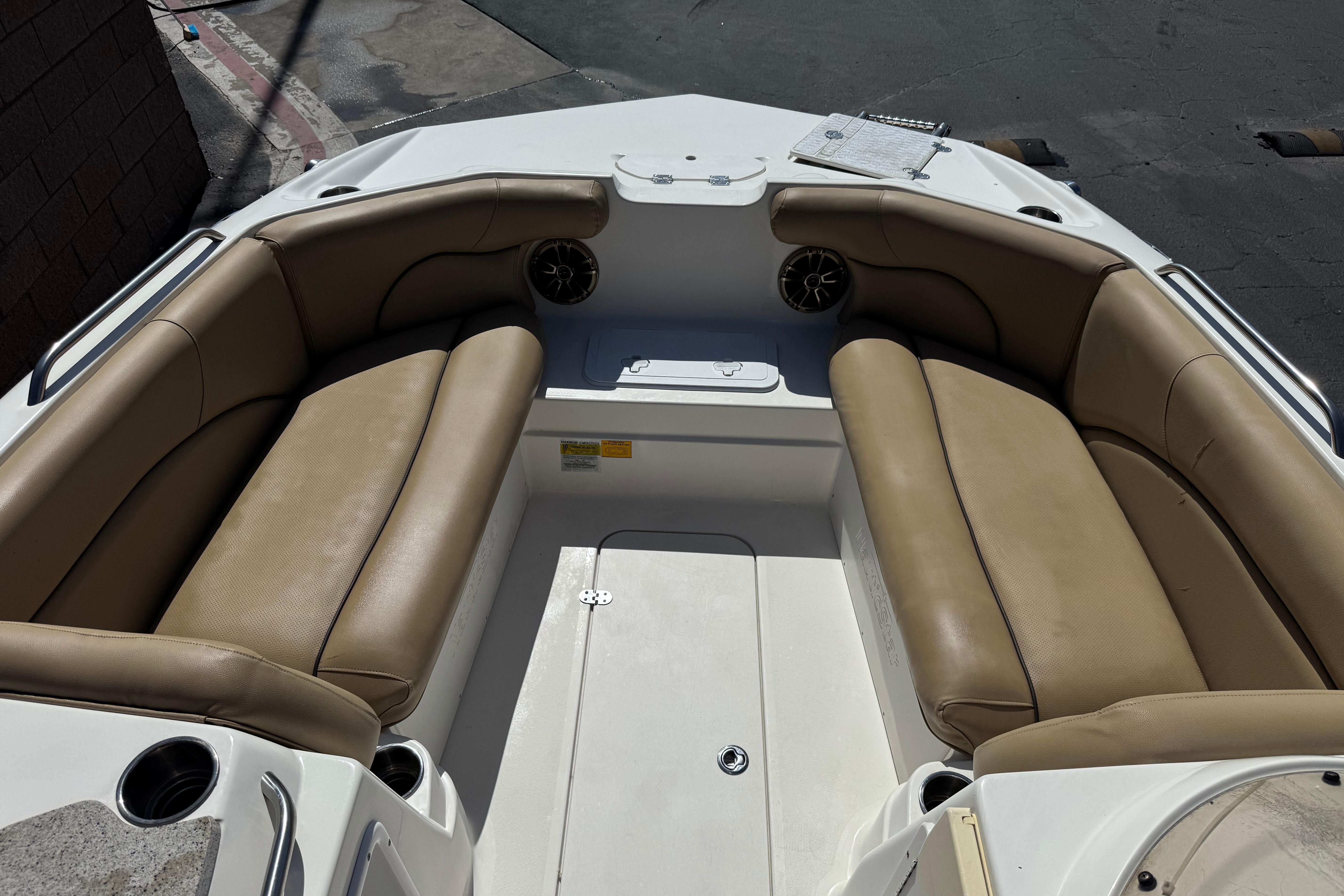 Interior view of 2020 NauticStar 203 SC boat with tan seating and cup holders.