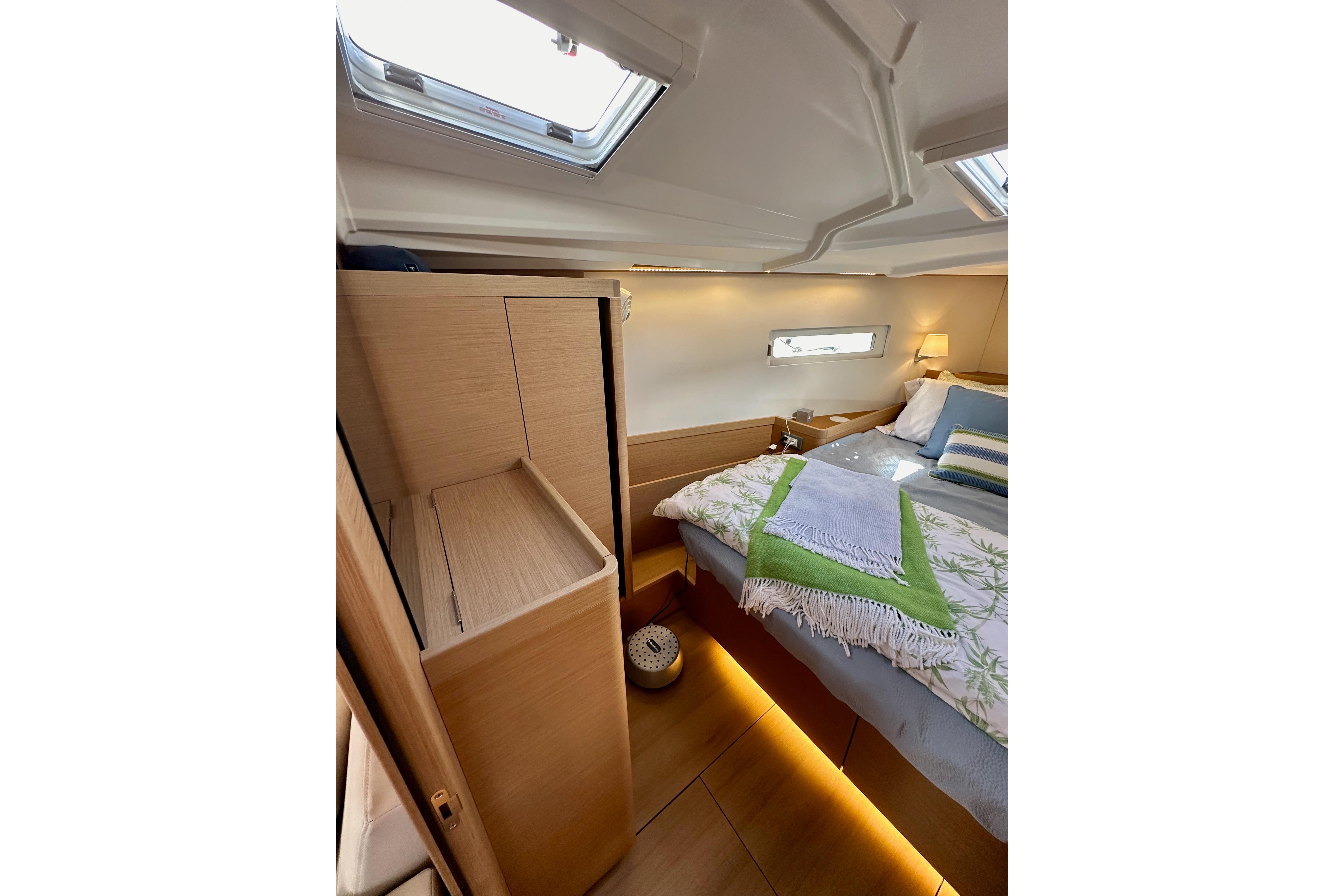 Luxurious interior of 2024 Jeanneau Sun Odyssey 410 yacht cabin with cozy bedding.
