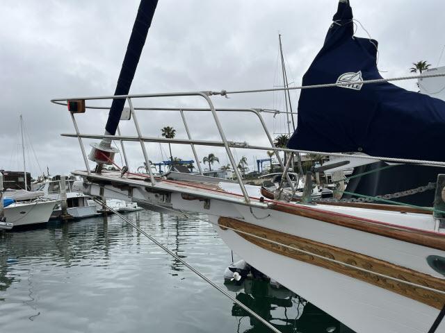 Sailboat docked in marina, Bluewater Vagabond 47, 1983 model, overcast sky.