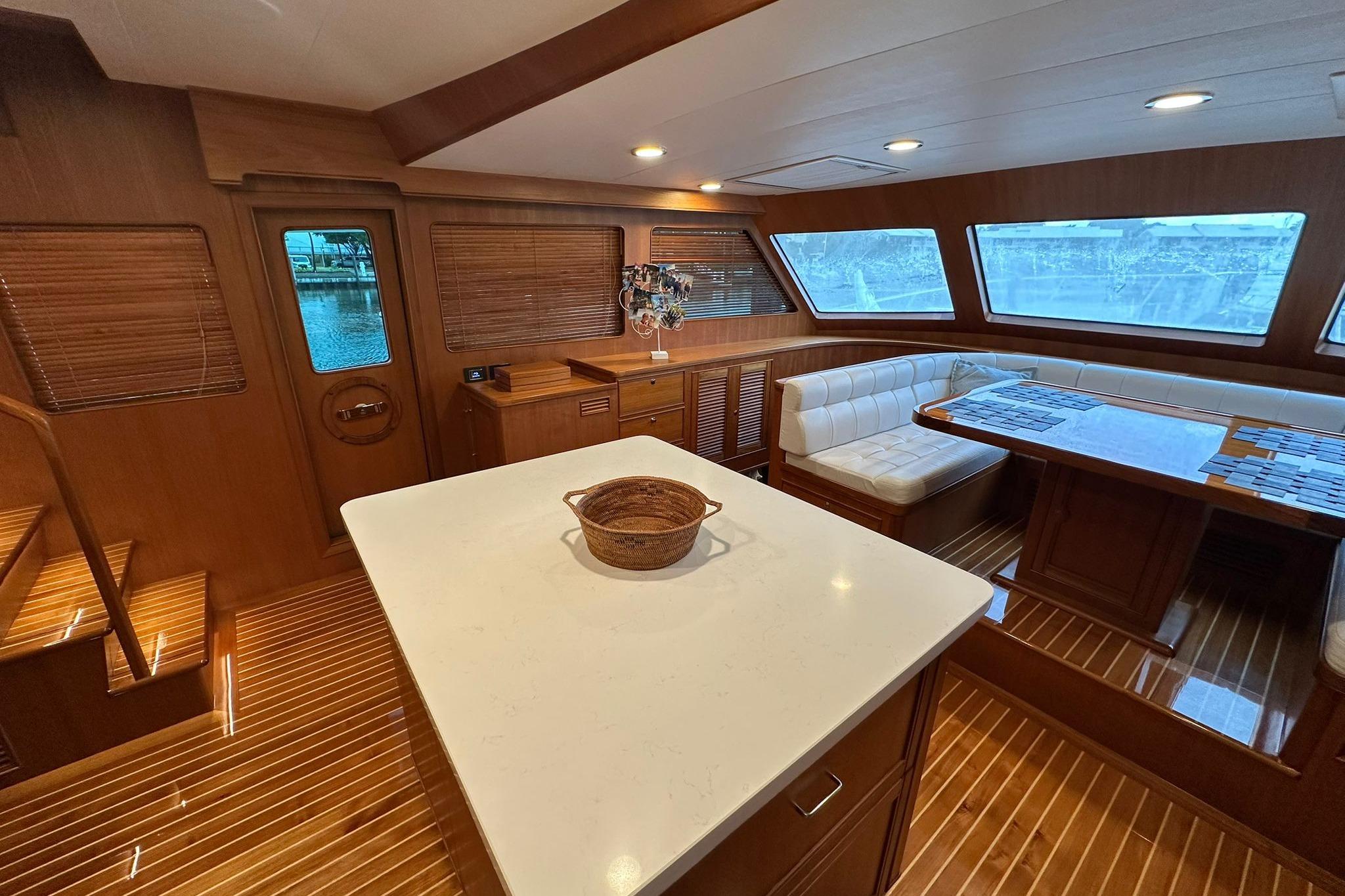 Luxurious interior of 2023 Marlow Explorer 66E-CB yacht with elegant wood finishes and seating area.