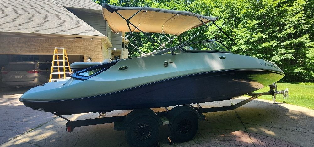 2007 Sea-Doo Sport Boats 230 Challenger SE on trailer, with sunshade, parked in front of a house.