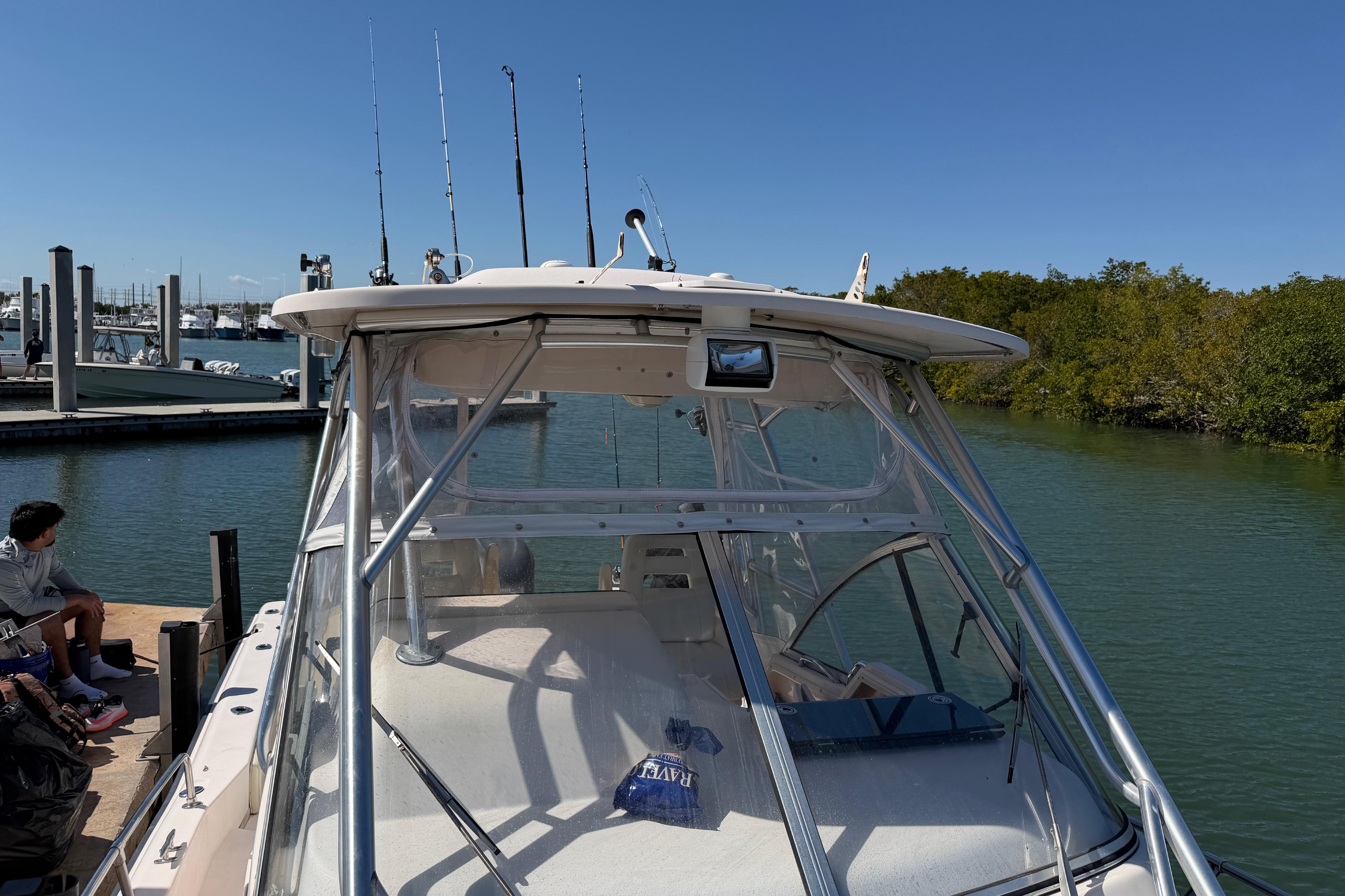 2006 Grady-White Sailfish 282 boat docked by a marina with fishing rods.
