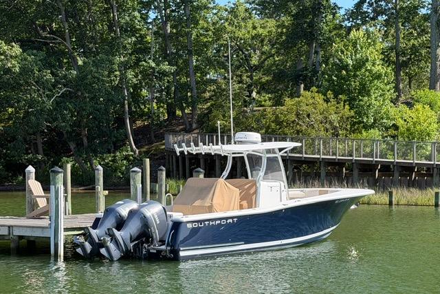 2014 Southport 29 FE boat docked by a lush, wooded shoreline.