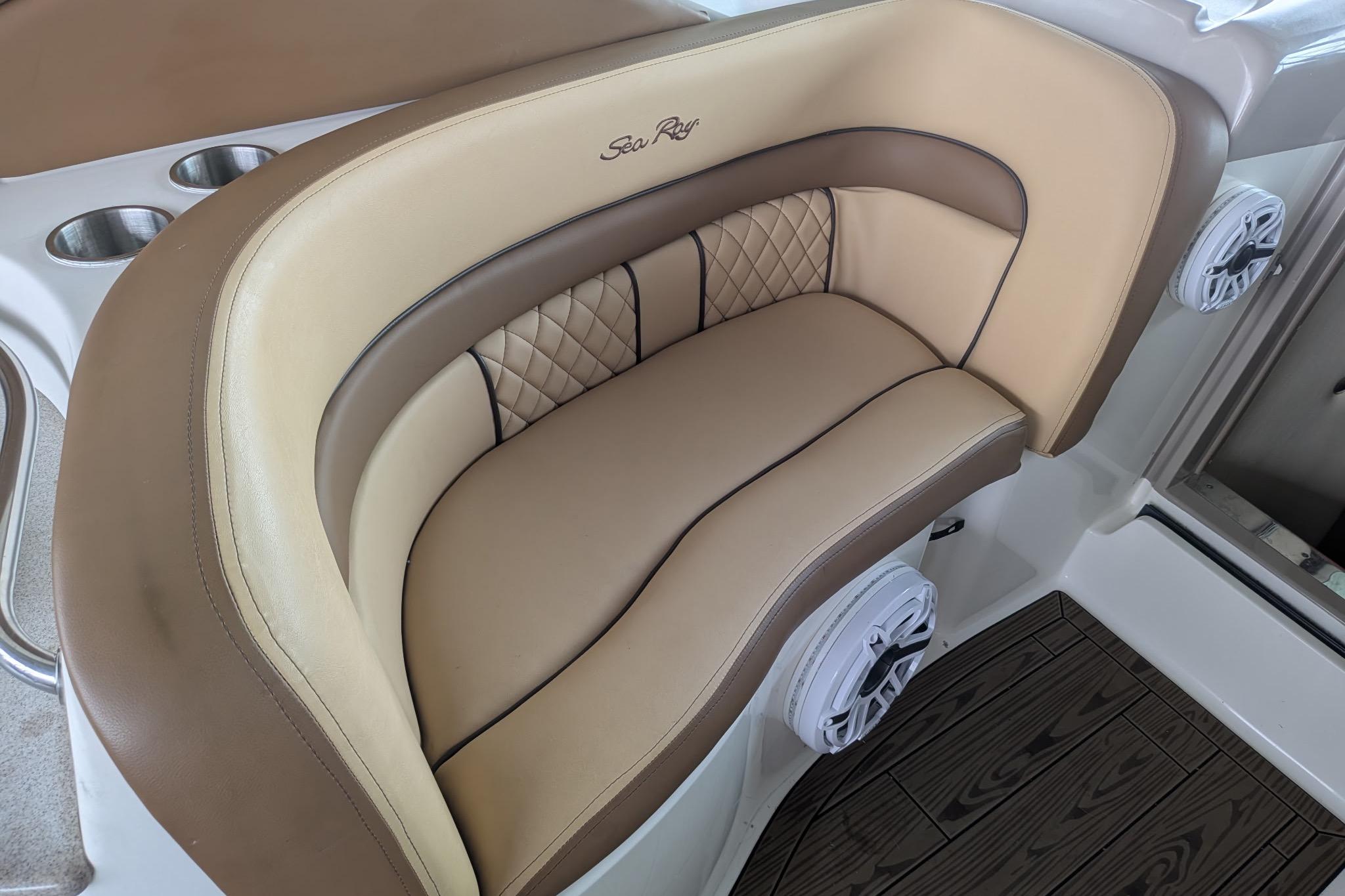 Luxurious seating on a 2002 Sea Ray Sundancer 320 boat with cup holders and speakers.