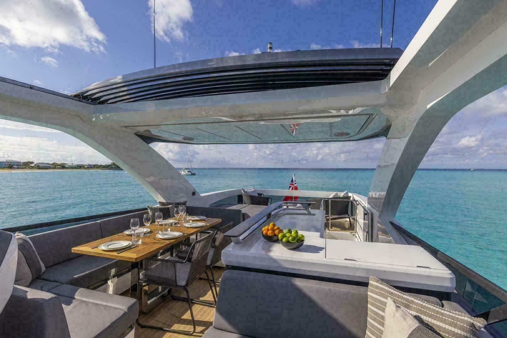 Luxurious Pearl 72 yacht deck with dining area, ocean view, and modern design, 2023 model.