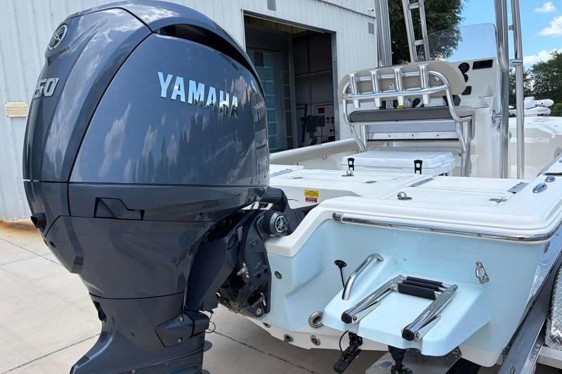 2025 Key West 210 Bay Reef boat with Yamaha outboard motor, docked near a building.
