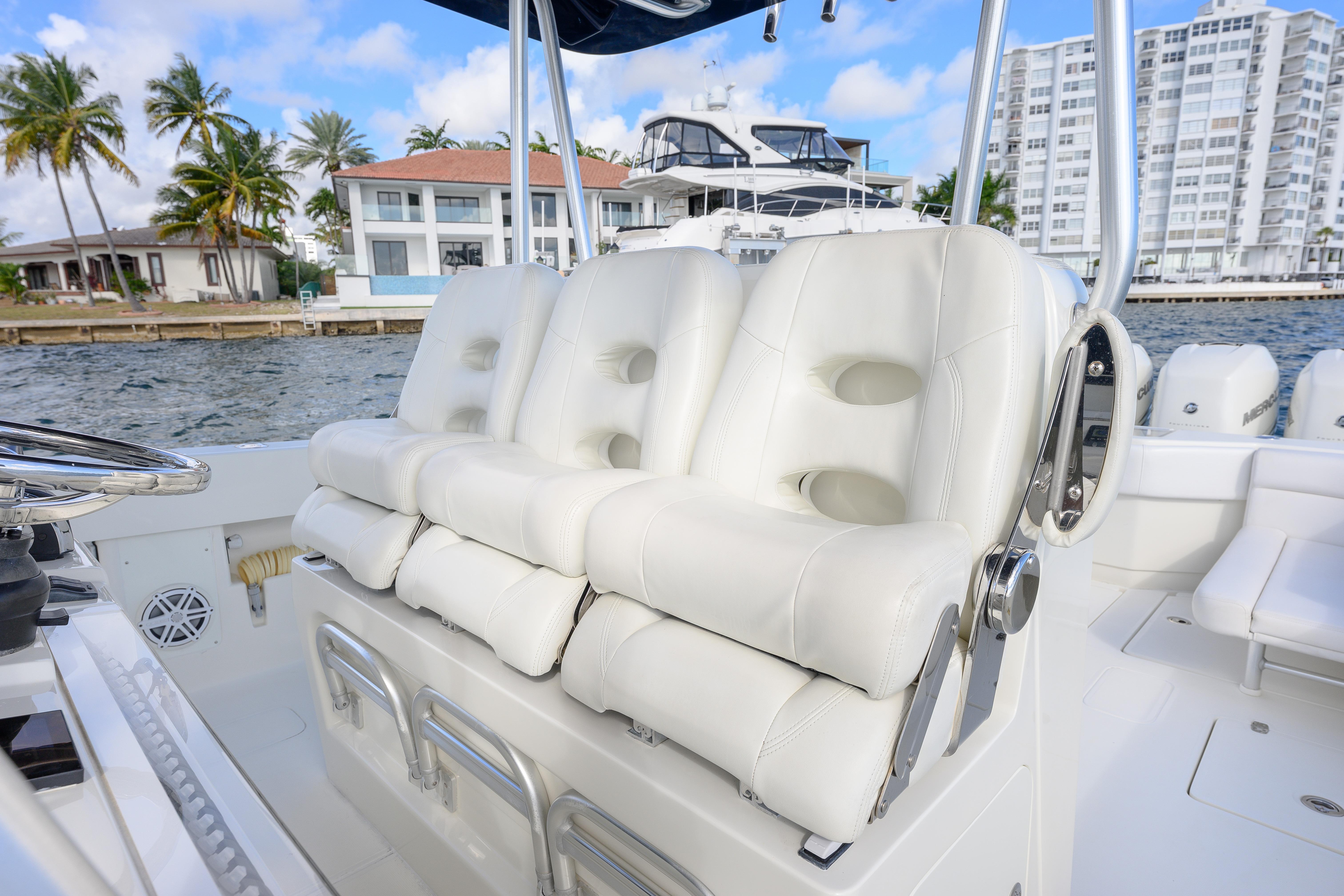 2017 SeaVee 390Z boat with white cushioned seats, dockside view, palm trees, and buildings.