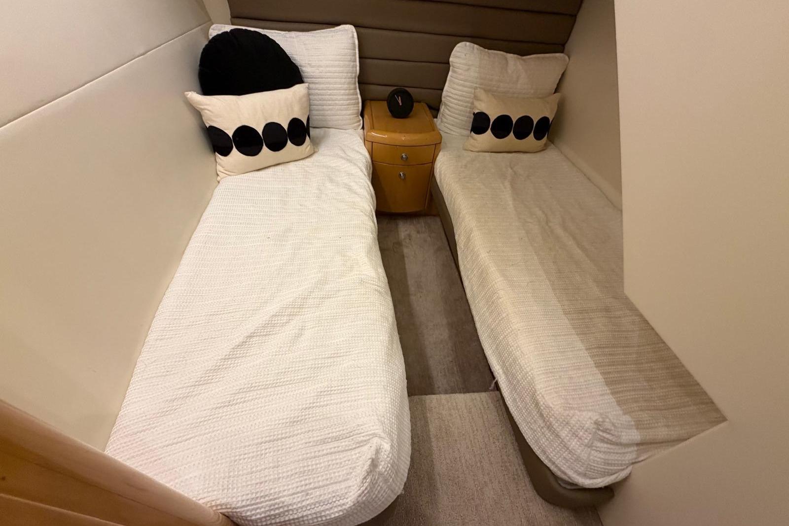Twin beds in a 2003 Hatteras 54 Convertible yacht cabin with decorative pillows.