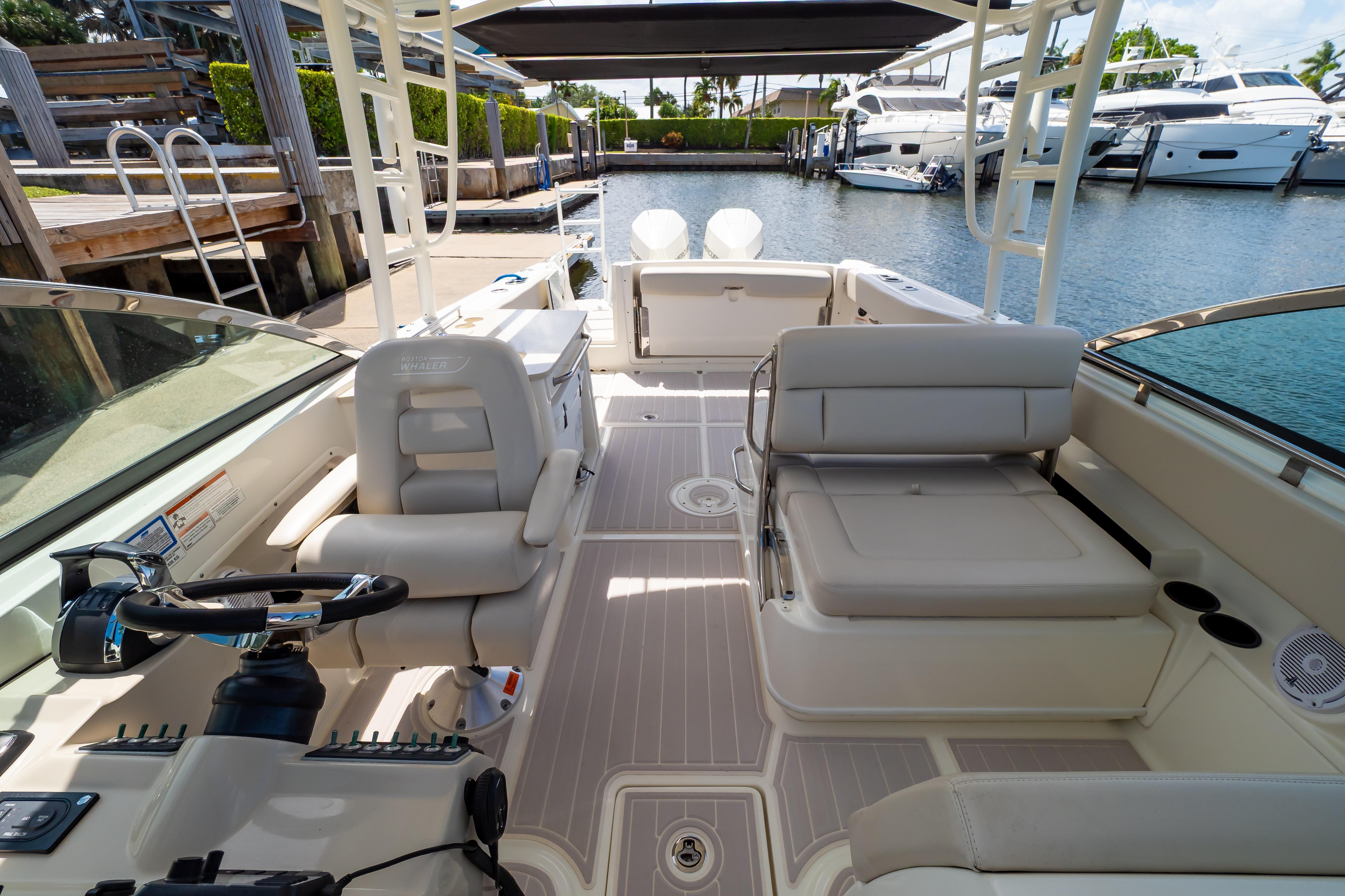 2019 Boston Whaler 270 Vantage boat interior with seating and steering wheel, docked at marina.