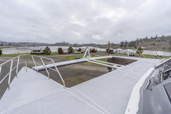 2025 Catamaran Bloomfield 86 Motorsailor on land, showcasing deck and surrounding landscape.
