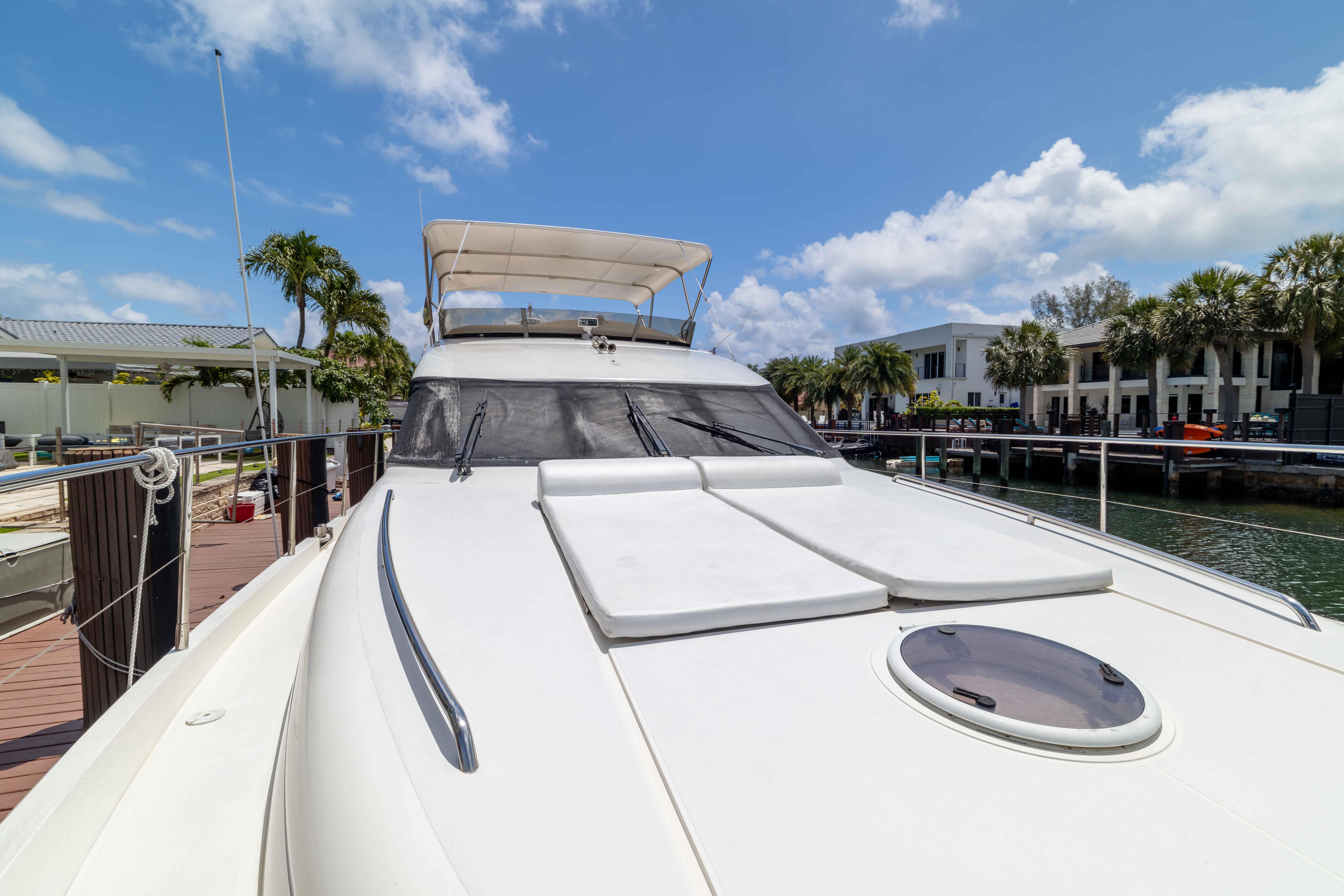 Luxurious 2002 Princess 61 yacht docked, featuring sleek design and spacious deck.