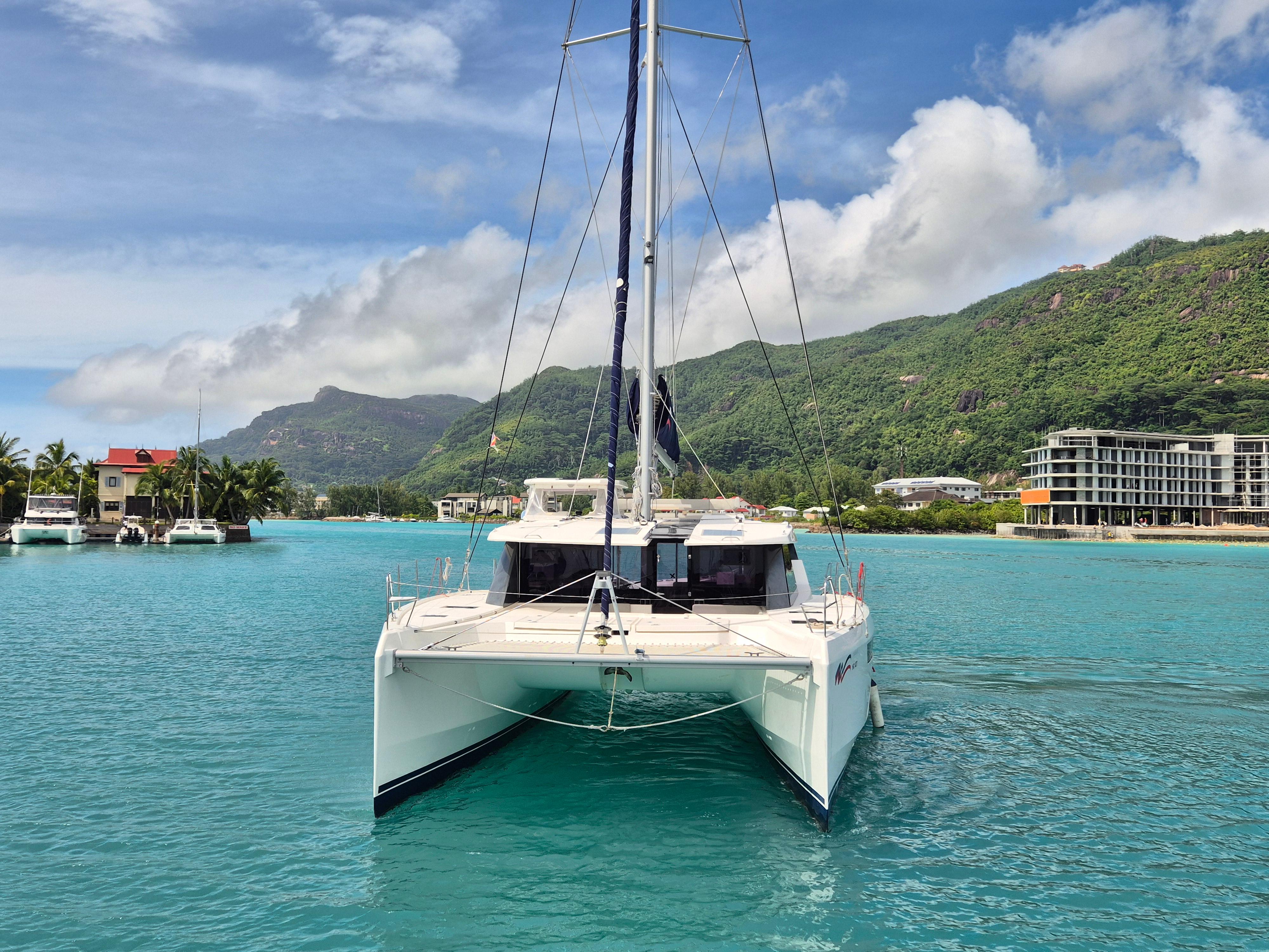 Leopard 50 catamaran sailing in turquoise waters with scenic mountain backdrop, 2020 model.