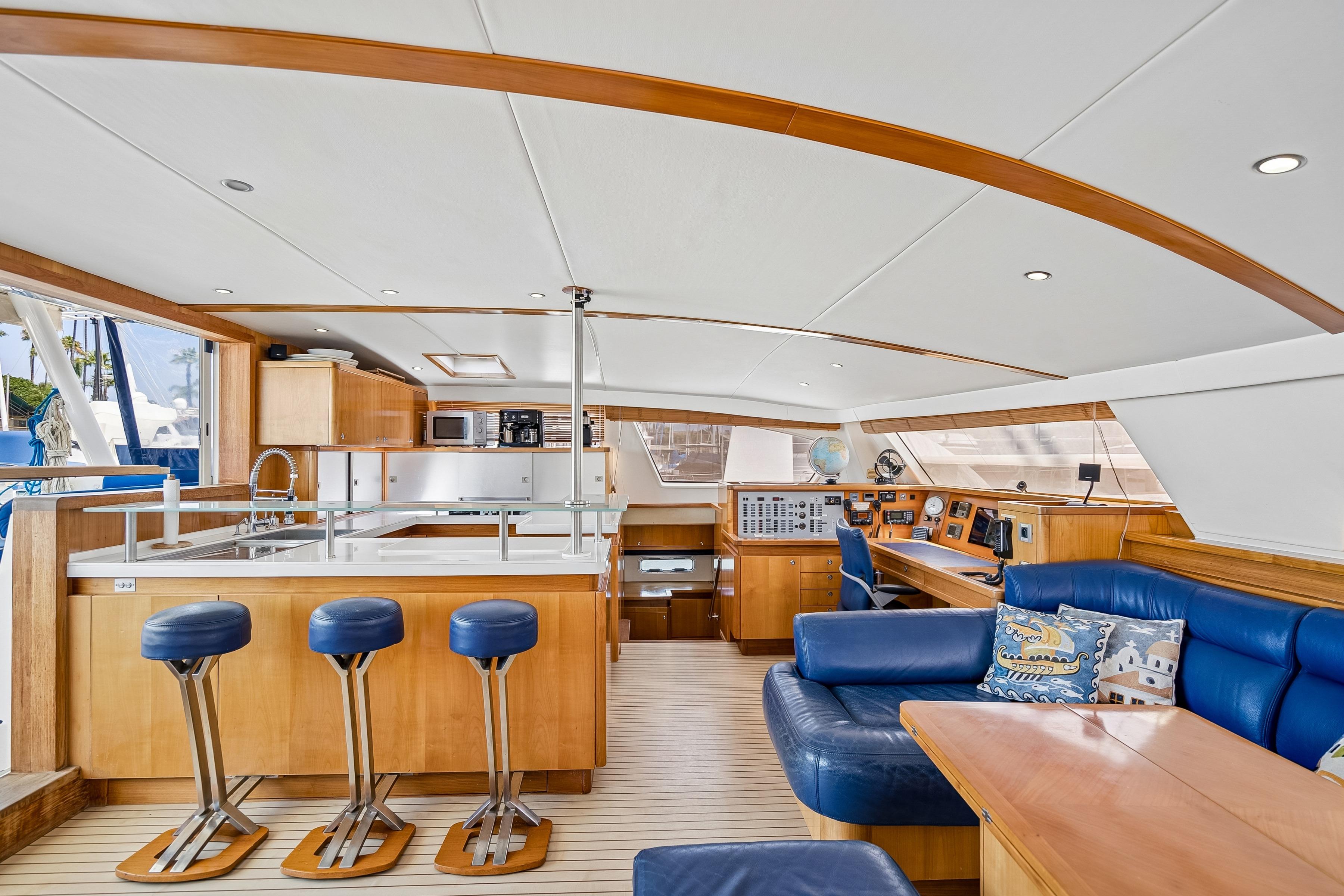 Luxurious interior of 2009 Catana 65 yacht with modern kitchen and blue seating.