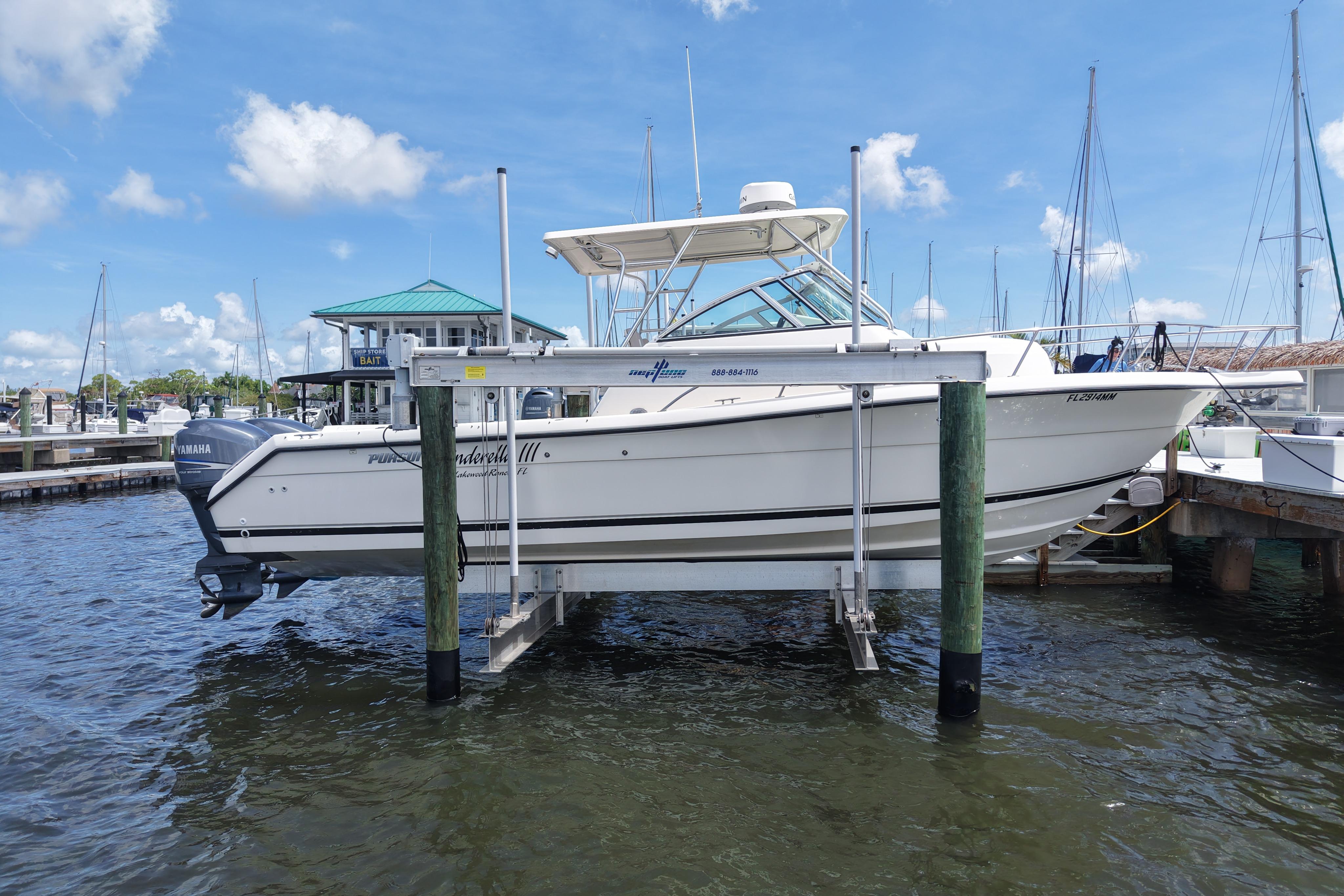 2004 Pursuit 2870 Walkaround boat docked at marina under clear blue sky.