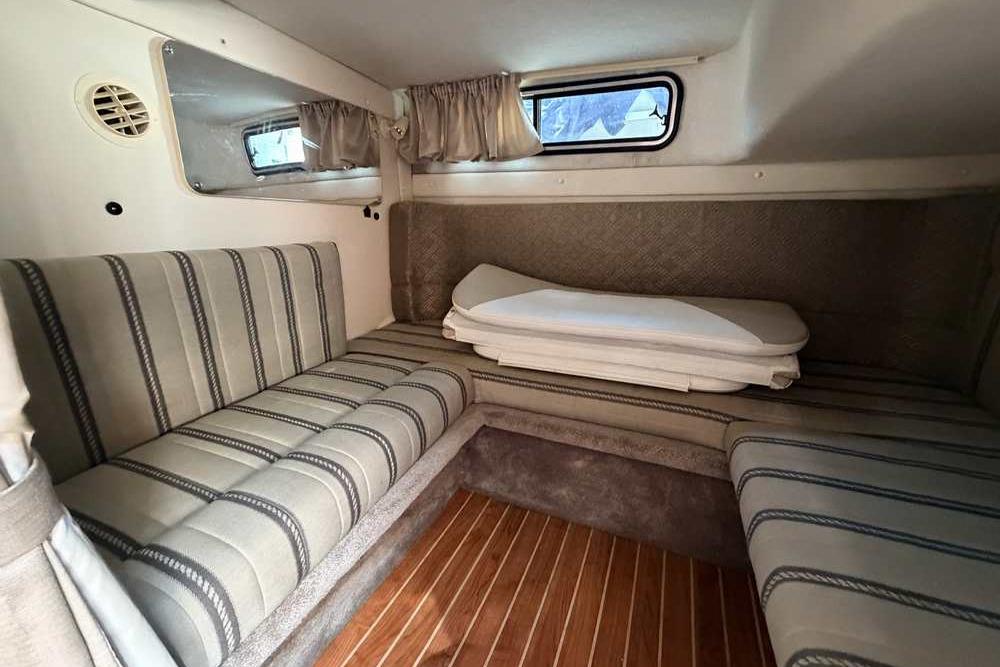 Interior cabin of a 2001 Monterey 282 Cruiser with striped seating and wood flooring.