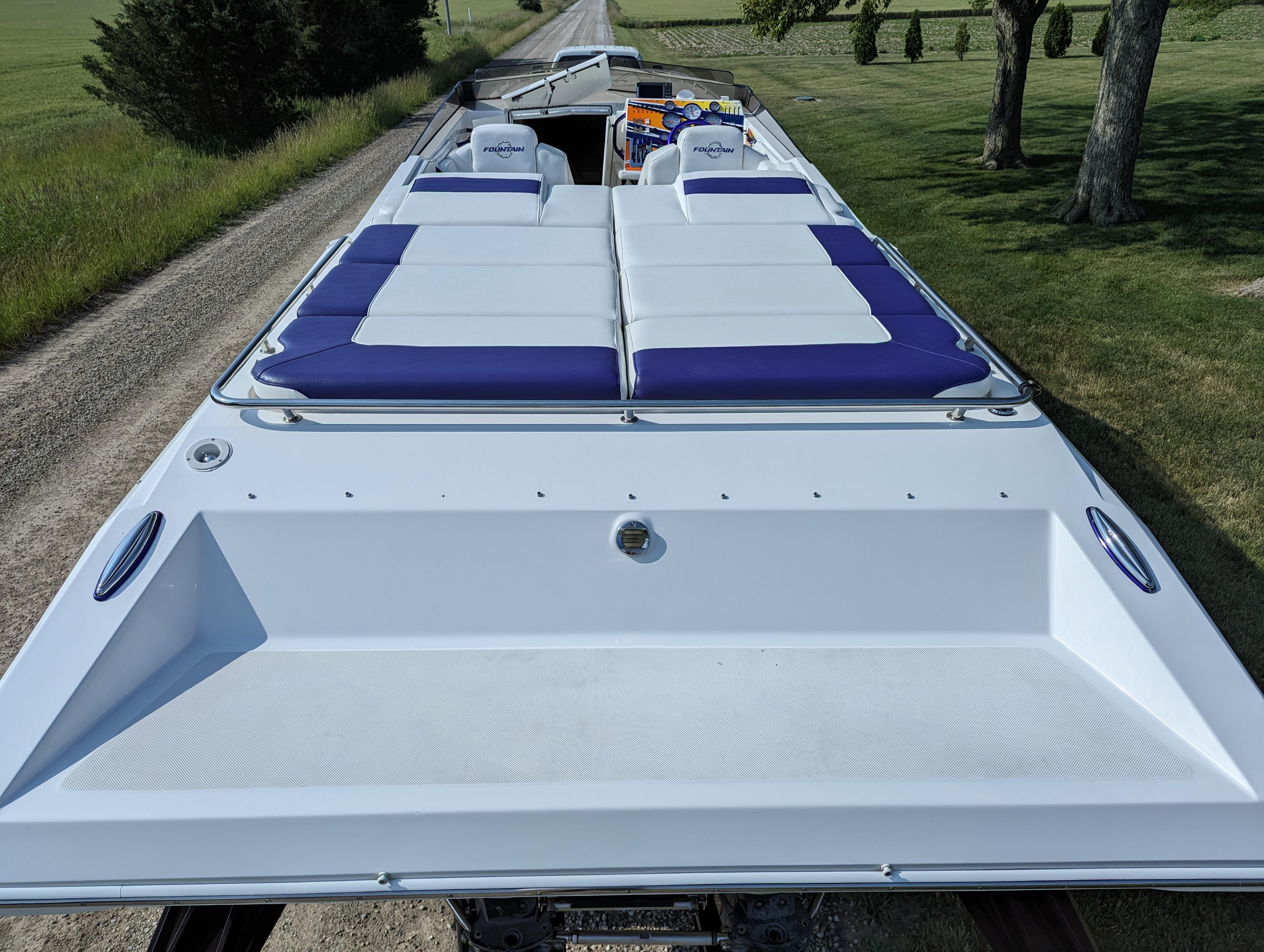 2006 Fountain 42 boat with white and blue seating on a rural road.