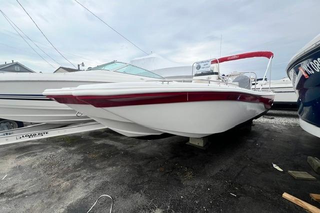 2013 NauticStar 210 Coastal boat with red accents, parked on a trailer.