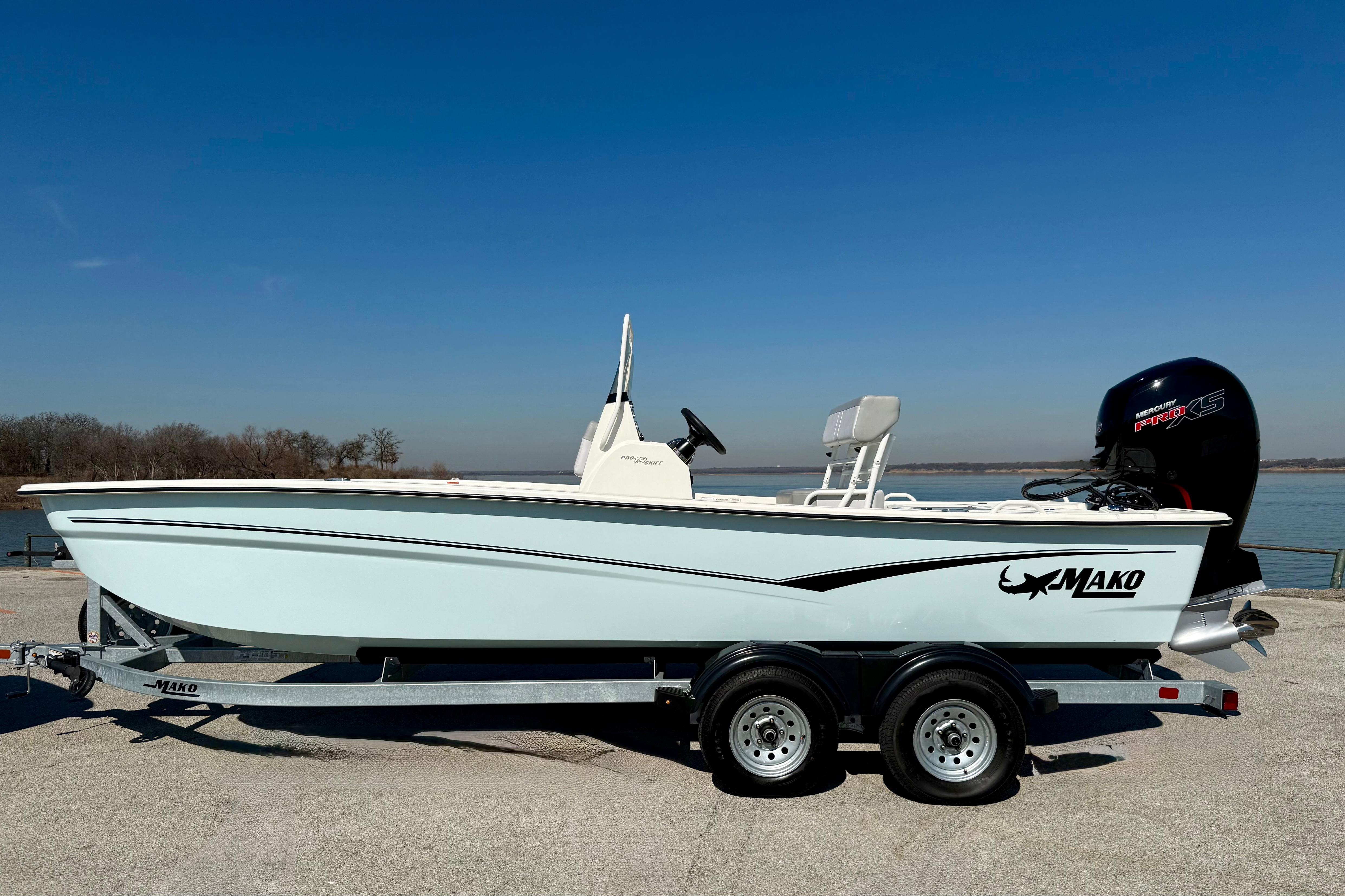 2024 Mako Pro Skiff 19 CC boat on trailer by a lake.