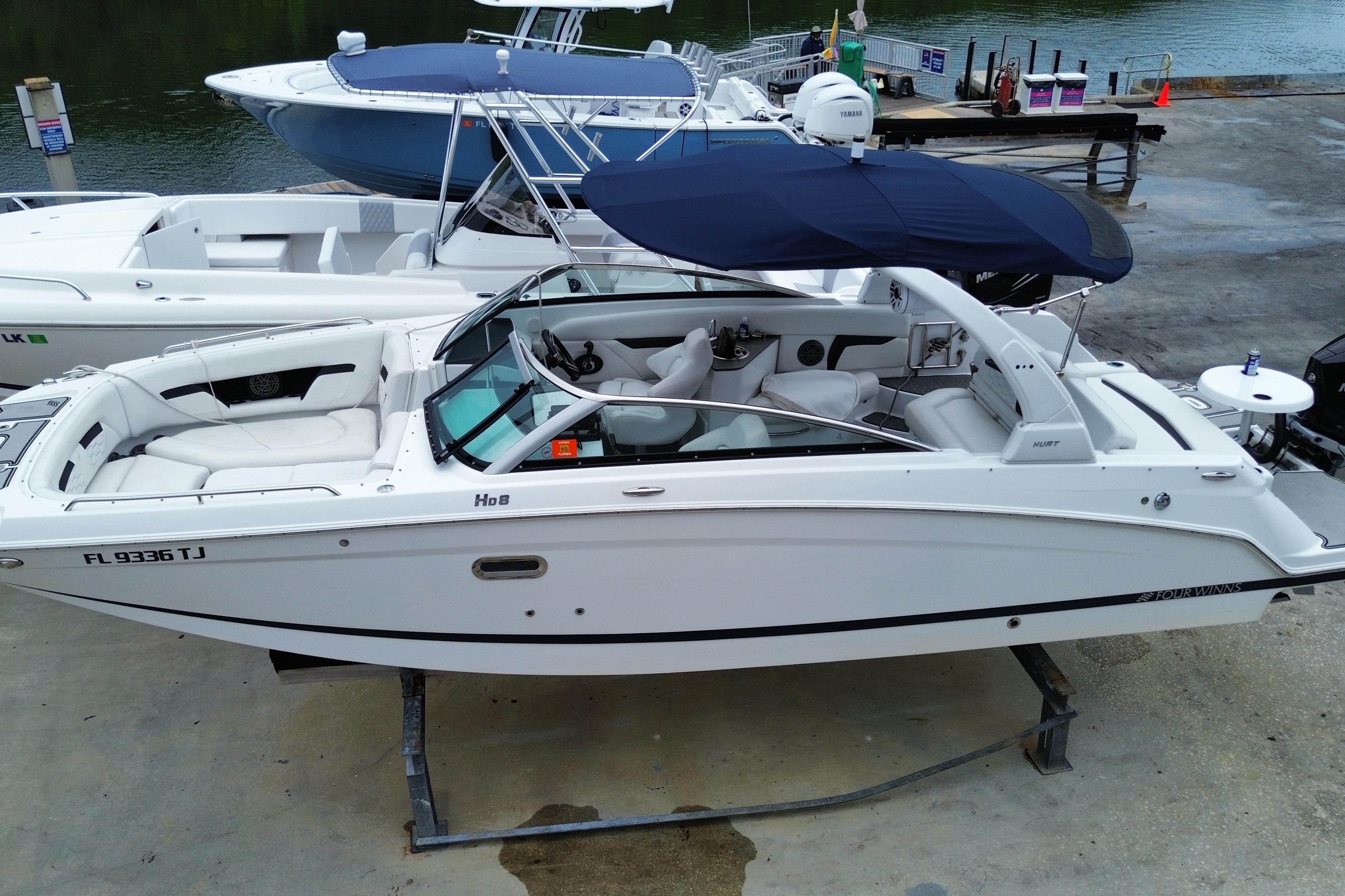2022 Four Winns HD8 OB boat with canopy, docked at marina.