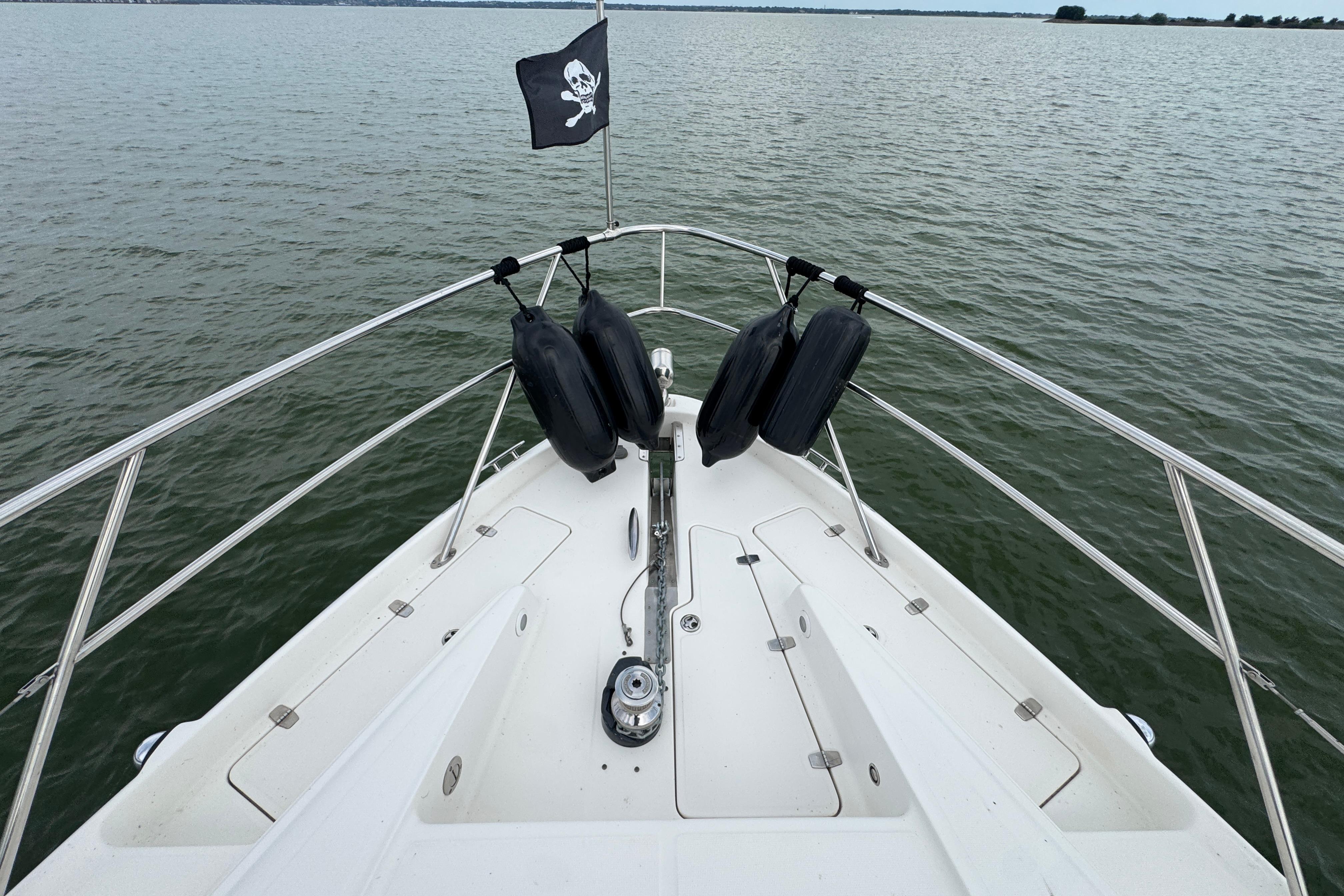 Bow of 2005 Regal Commodore 4260 yacht with pirate flag on calm water.