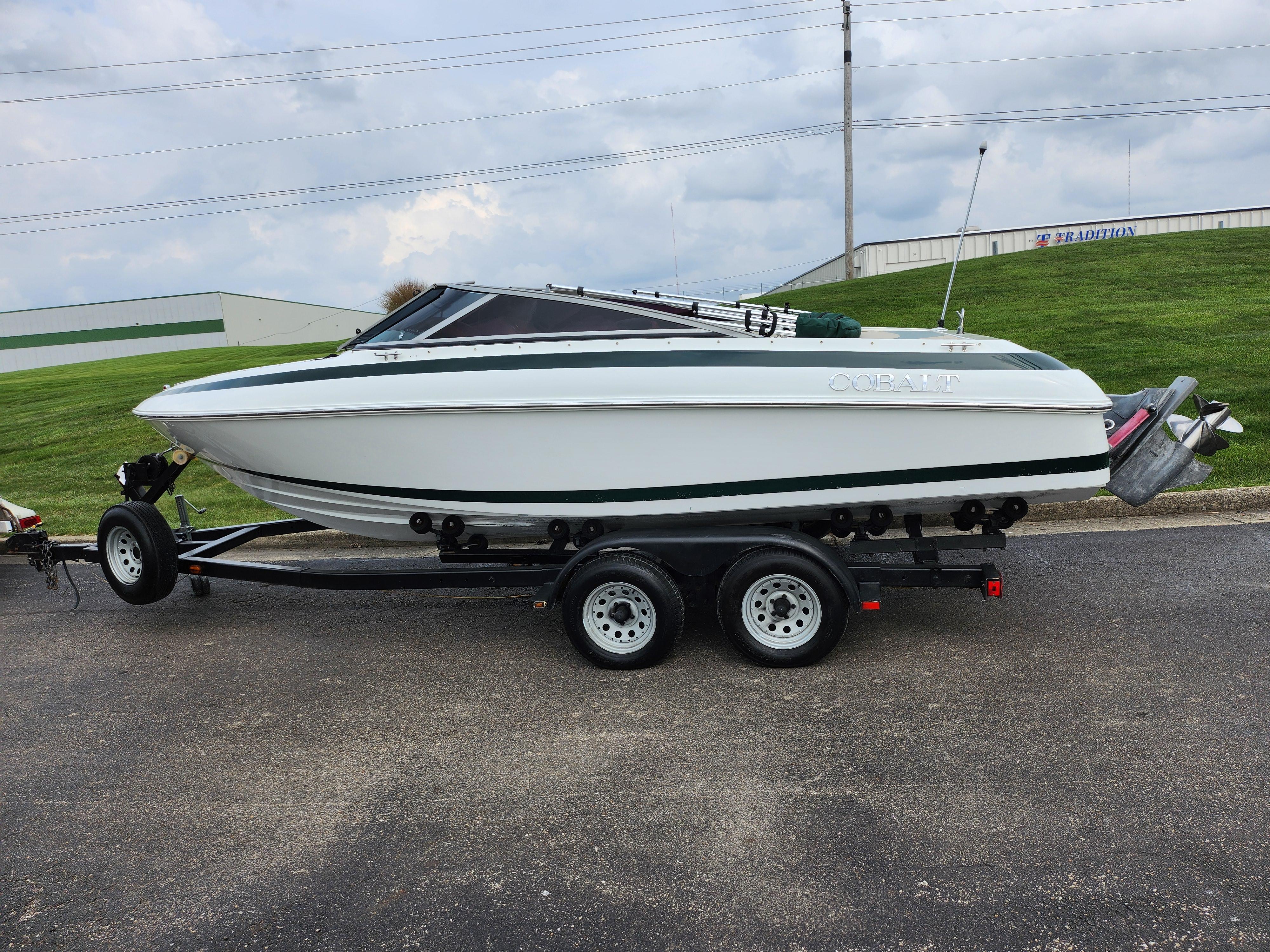 1998 Cobalt 200 boat on trailer, parked on road, overcast sky.