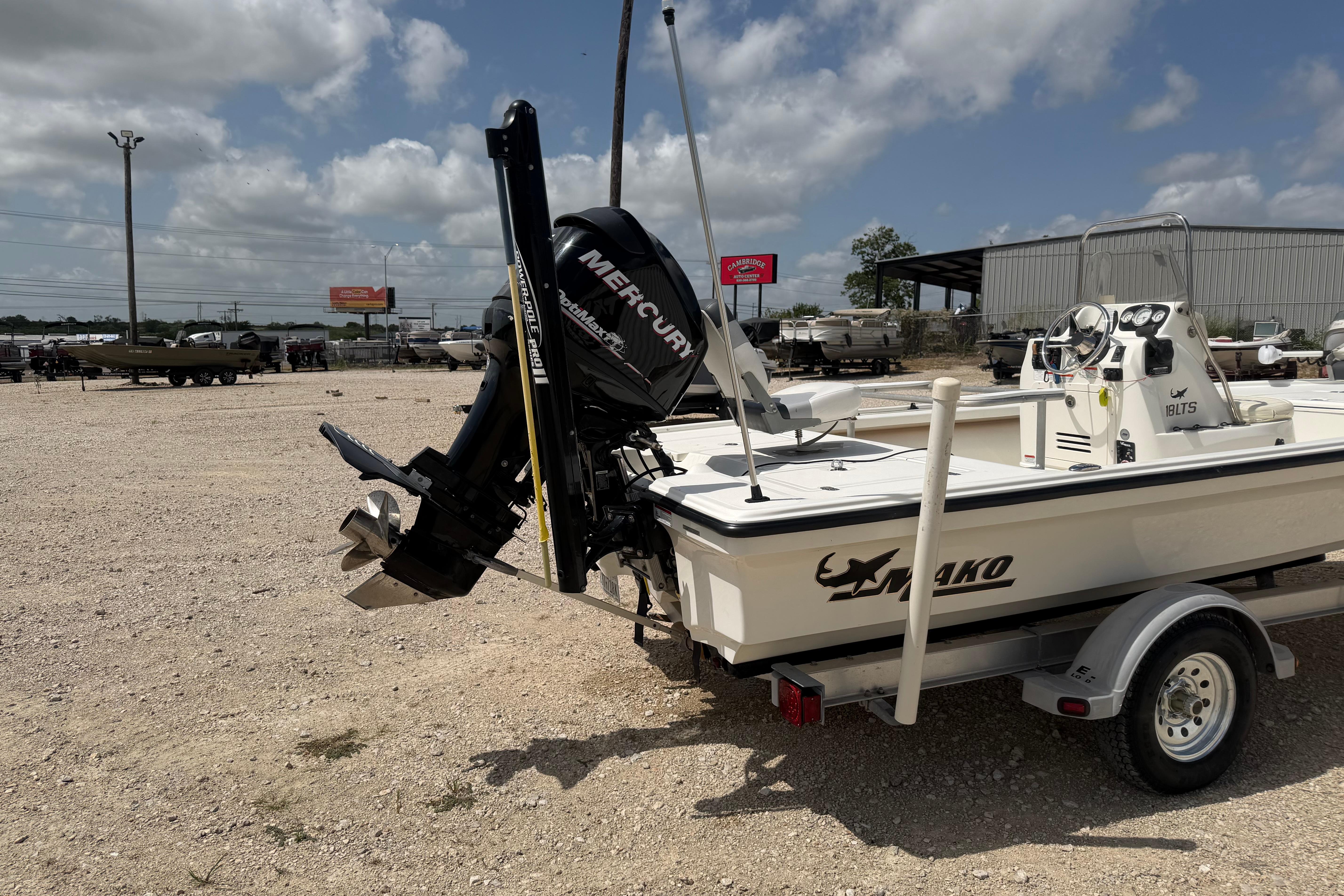 2012 Mako 18 LTS boat with Mercury engine on a trailer, parked outdoors.