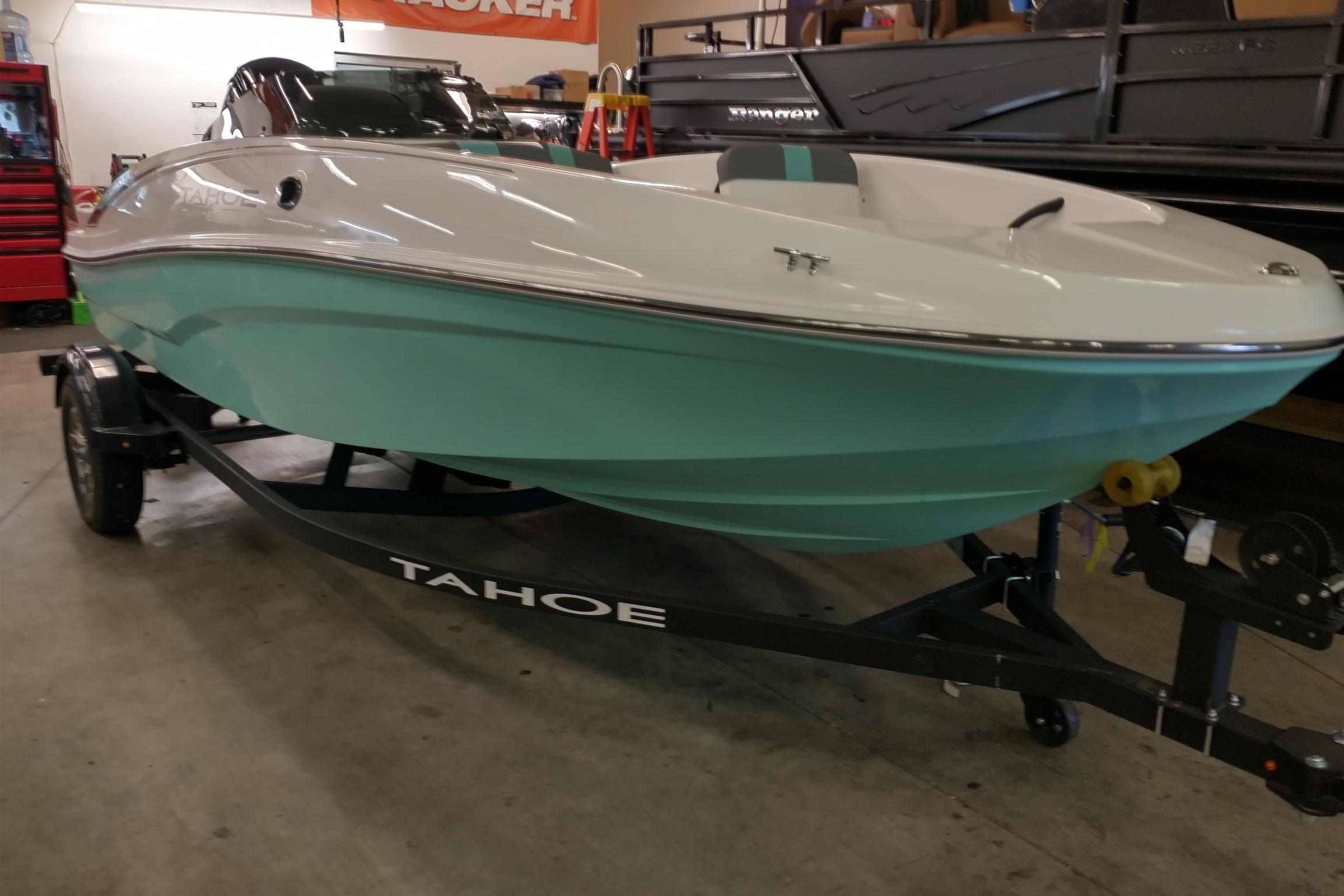 2026 Tahoe T16 boat in showroom, mint green hull, on trailer.