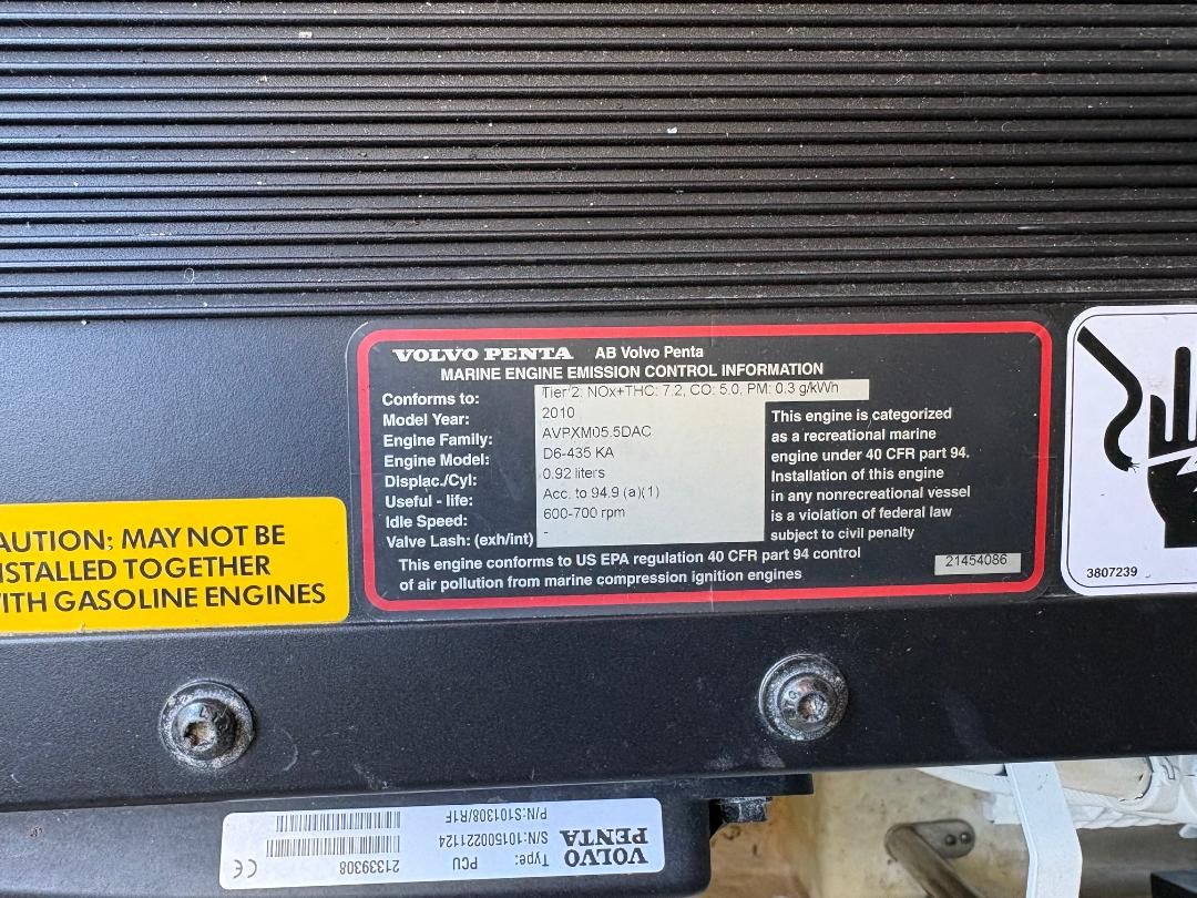 Volvo Penta engine with emission control information and warning labels, installed in a boat.