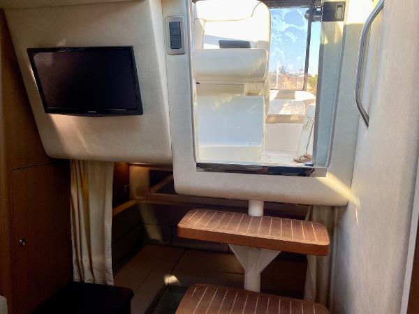 Interior of 2014 Sea Ray 330 Sundancer with TV and wooden steps.