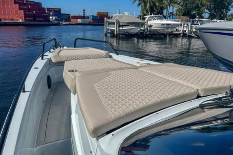 2023 BRABUS Shadow 900 ST luxury boat with beige seating, docked near other vessels.