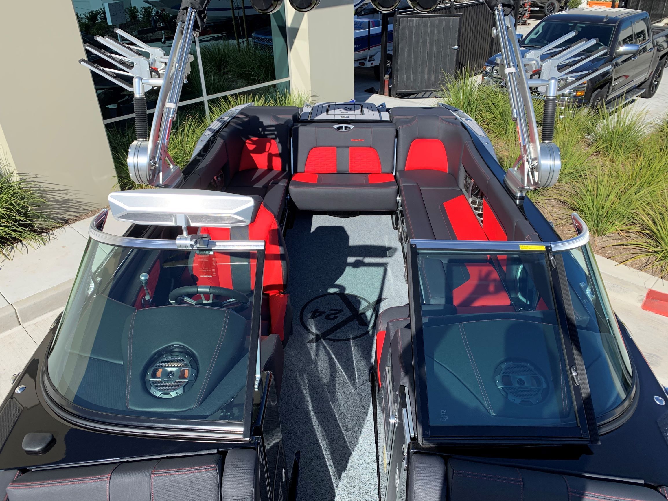 The image shows the interior of a 2020 MasterCraft X24 boat with red and black seating.