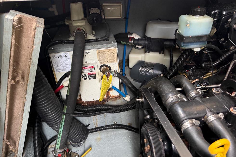 Engine compartment of a 1999 Sea Ray 290 Sundancer boat, showing mechanical components and hoses.