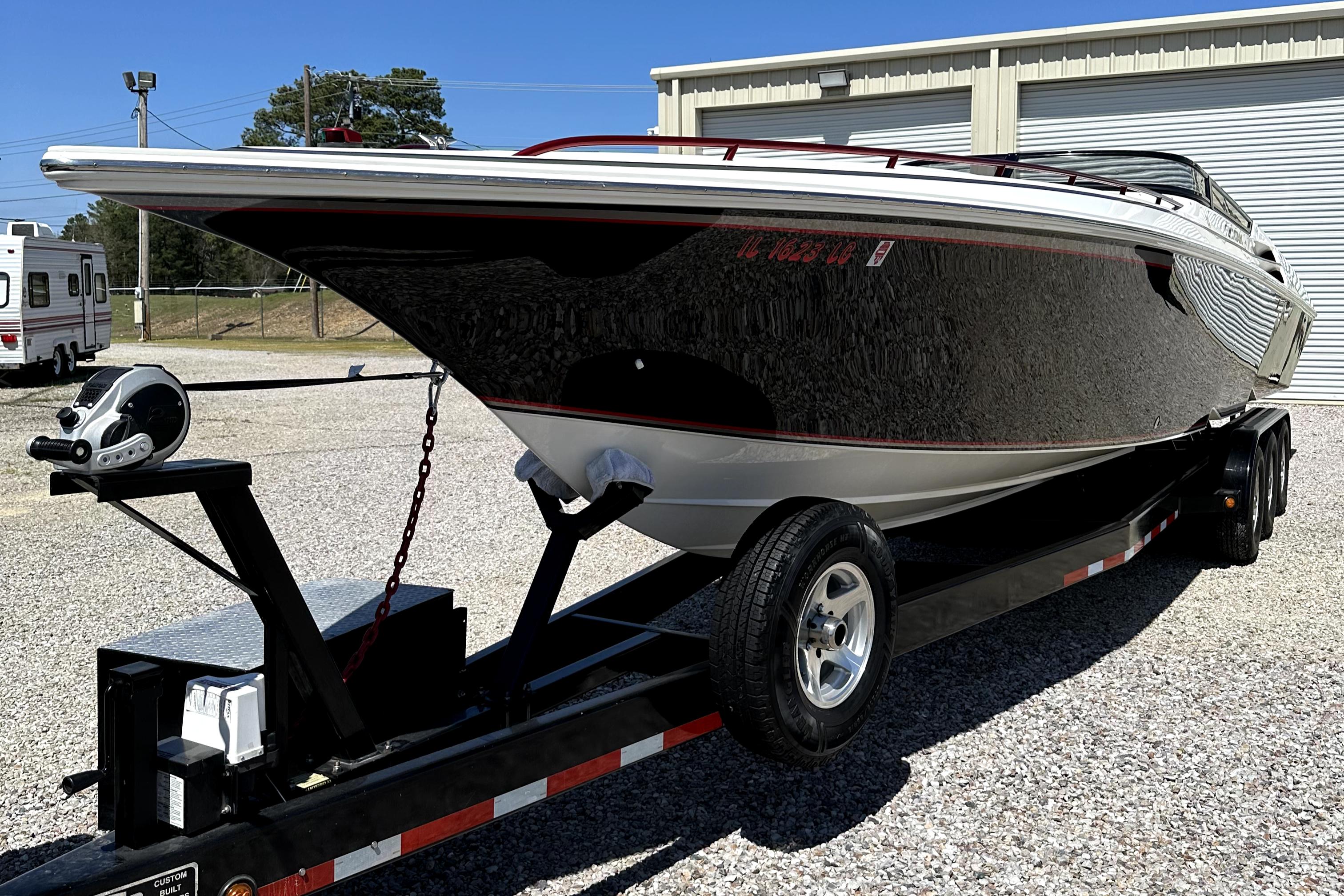 2003 Fountain 38 Lightning speedboat on a trailer in a parking lot.