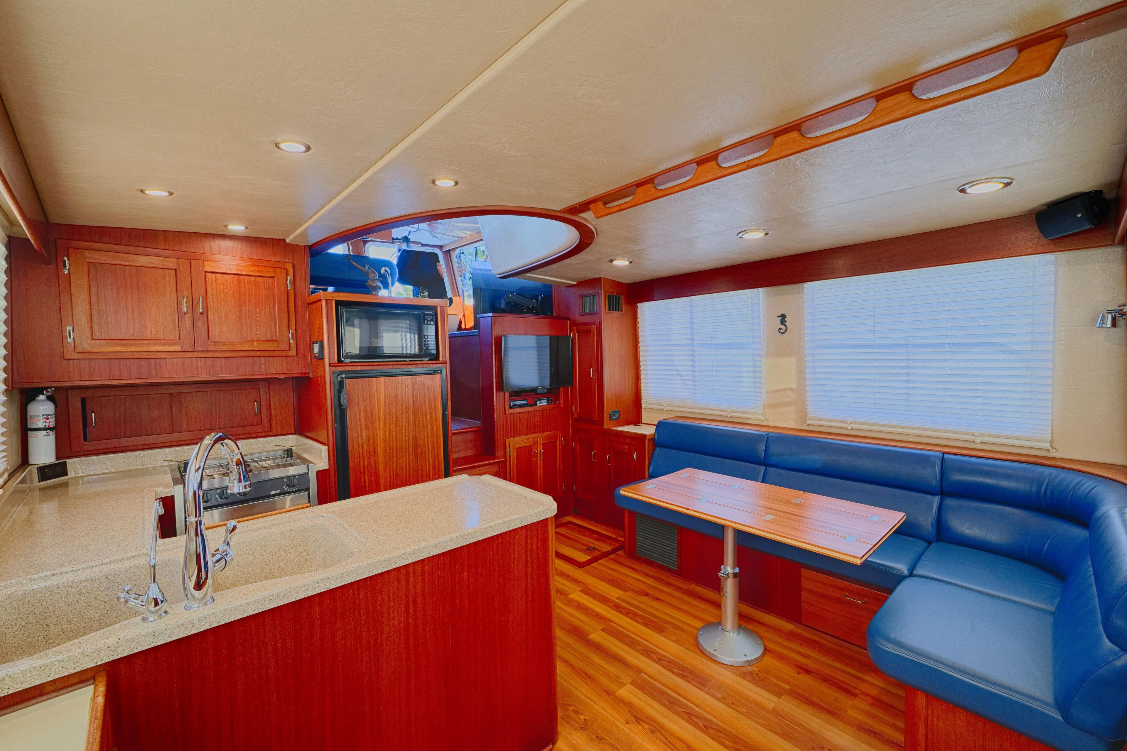 Luxurious interior of 2007 American Tug 41 with wood finishes and blue seating.