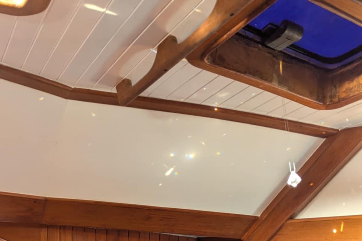 Interior ceiling of 1984 Liberty 458 boat with wooden beams and skylight.