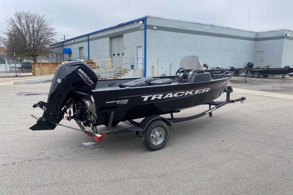 2026 Tracker Pro Guide V-16 SC boat on trailer in industrial area.