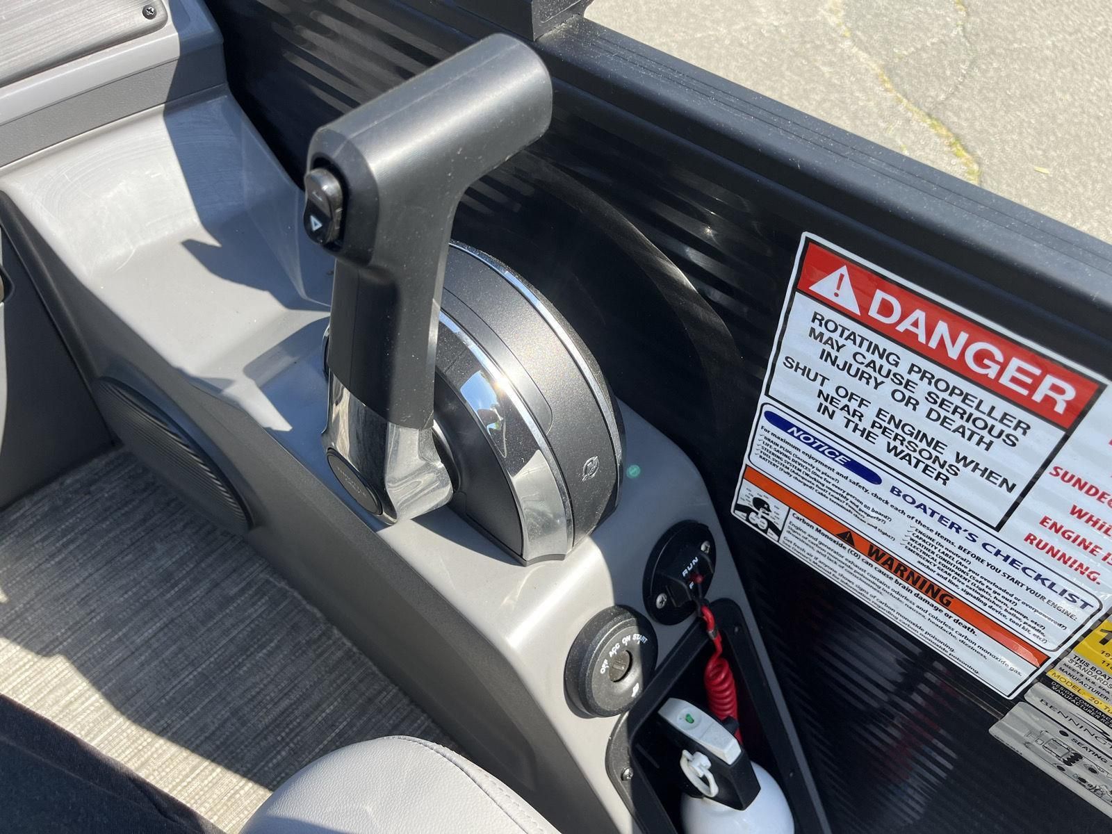 Close-up of the throttle lever on a 2025 Bennington S20 boat with warning labels.
