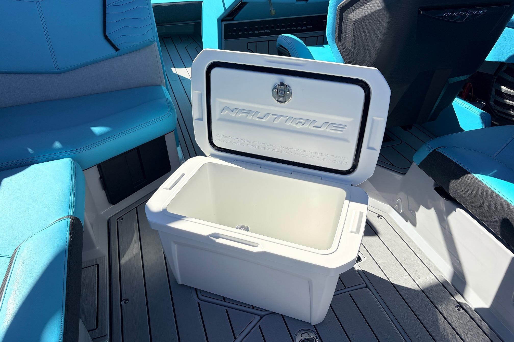 Open cooler on 2026 Nautique Super Air Nautique G23 boat with blue seating.