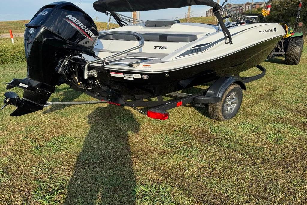 2026 Tahoe T16 boat with Mercury engine on a trailer, parked on grass.
