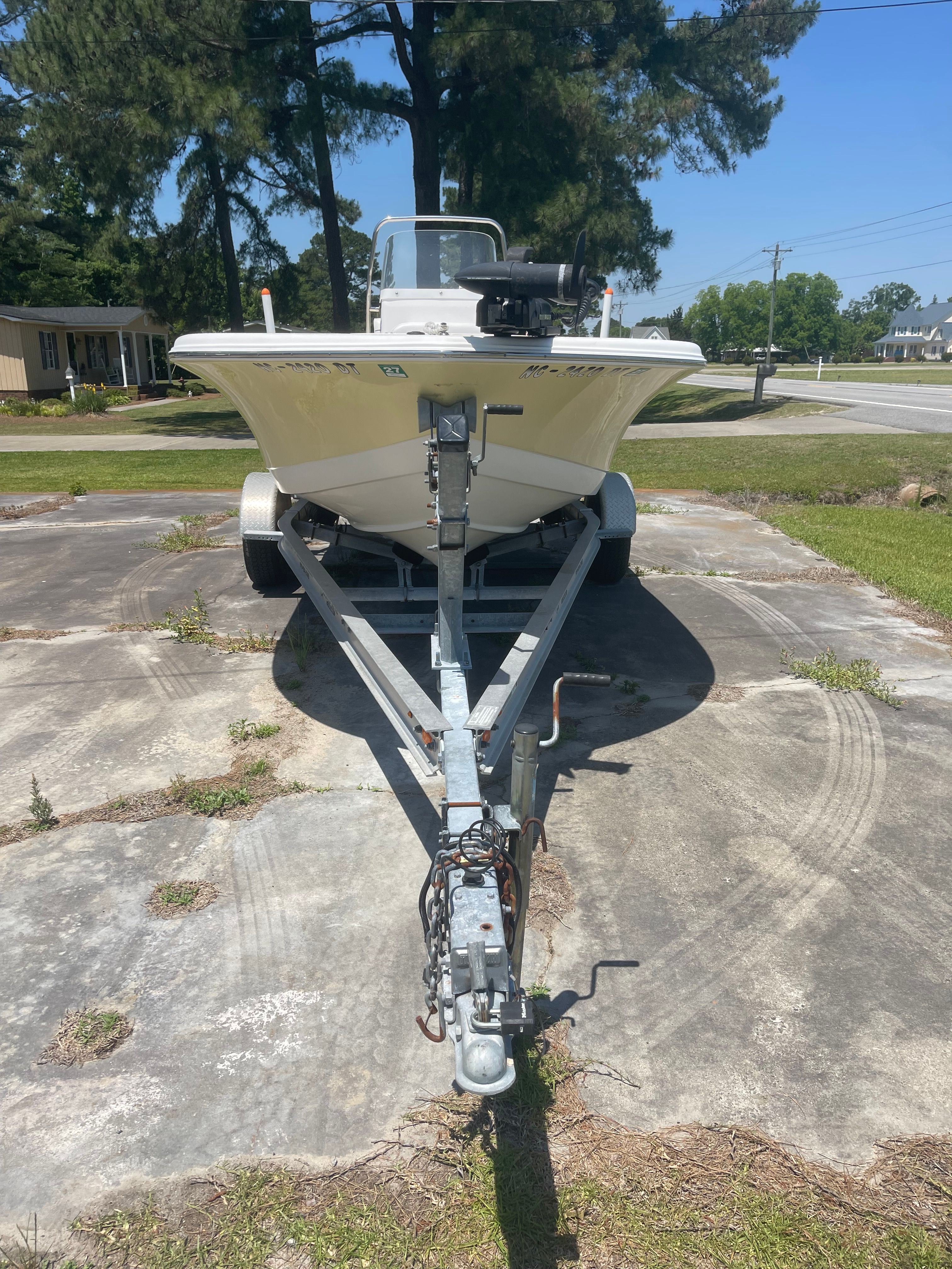 A Tidewater 180 CC Adventure boat on a trailer, parked on a concrete surface.