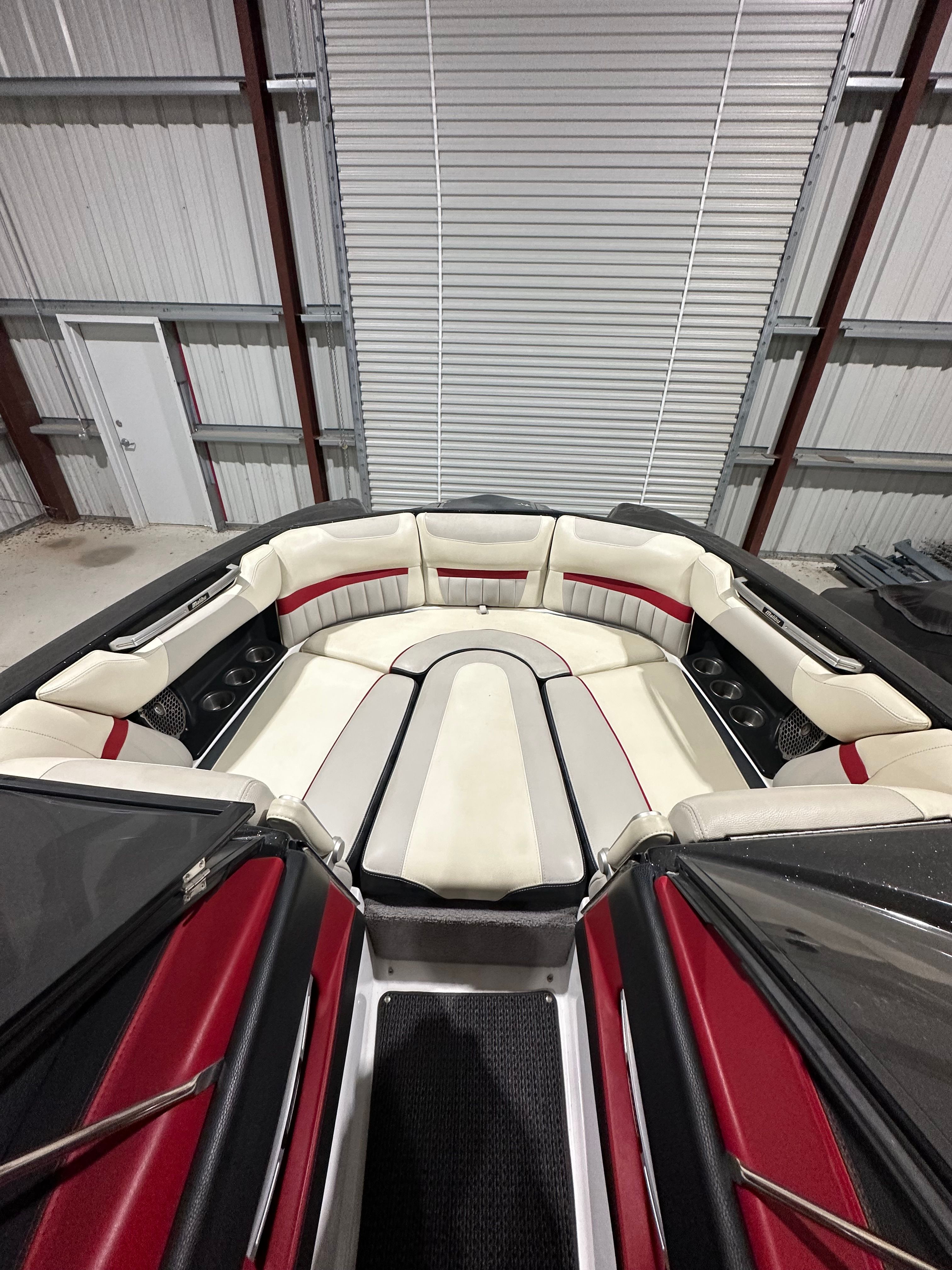 The boat features a luxurious interior with red and white seating inside a warehouse.