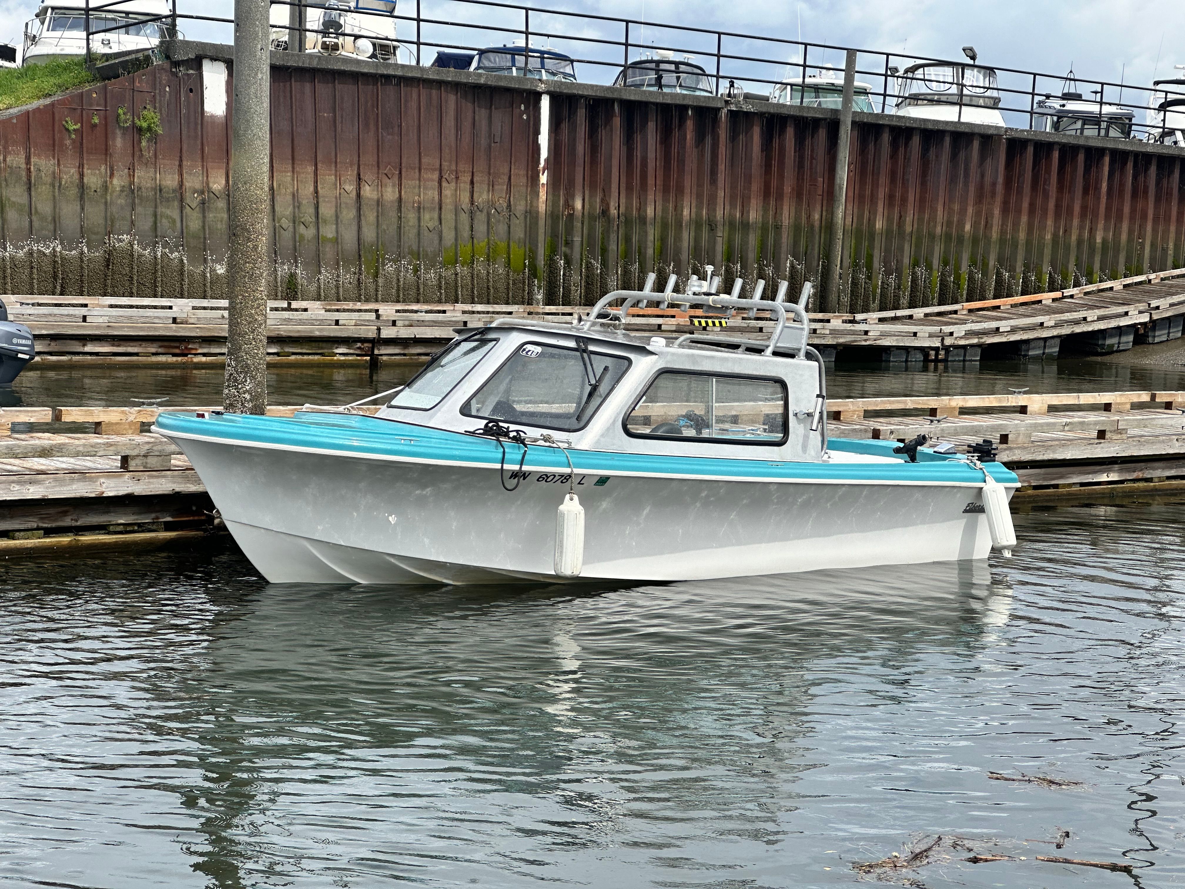 A restored 1967 Fiberform boat is docked in the water.