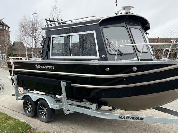 2024 Spartan 220 Maximus boat on Karavan trailer, parked on a residential street.