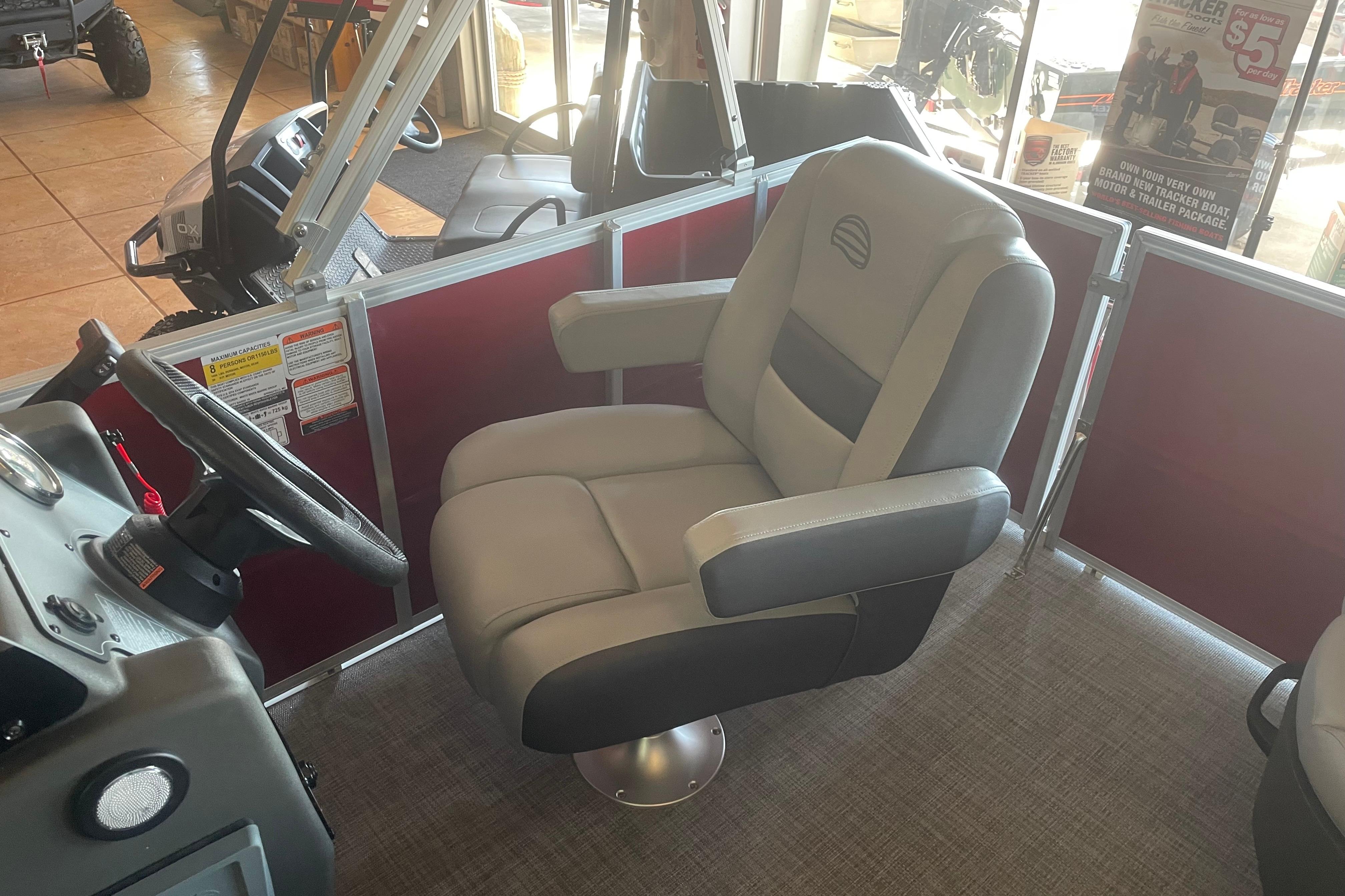 2026 Sun Tracker Party Barge 16 DLX interior with comfortable captain's chair and steering wheel.