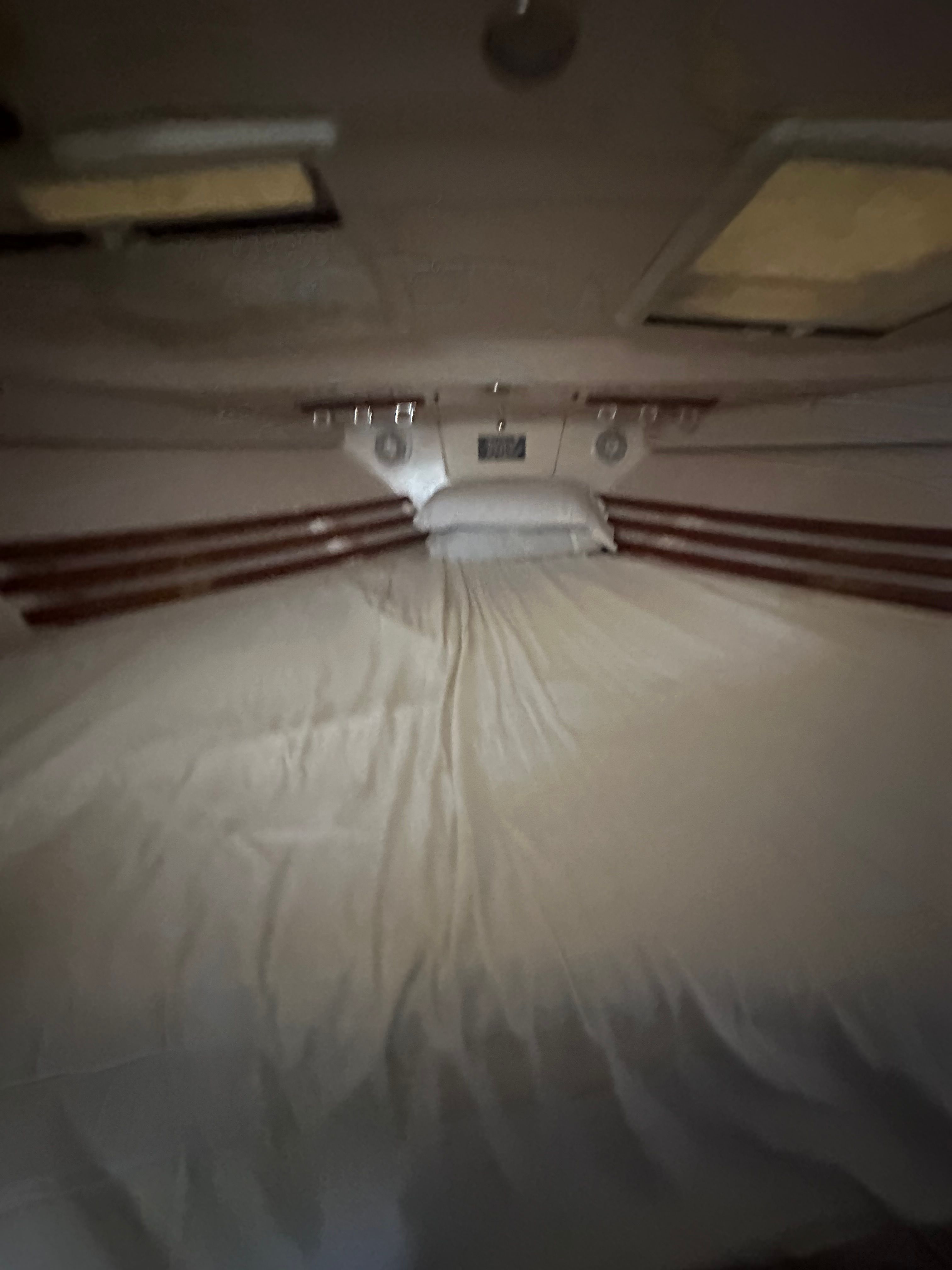 Interior of a 2003 Grady-White Express 330 with a cozy bed and wood paneling.