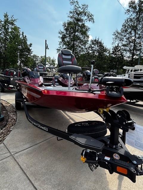 2025 Ranger RT188P boat in showroom, red exterior, parked on trailer, surrounded by trees.